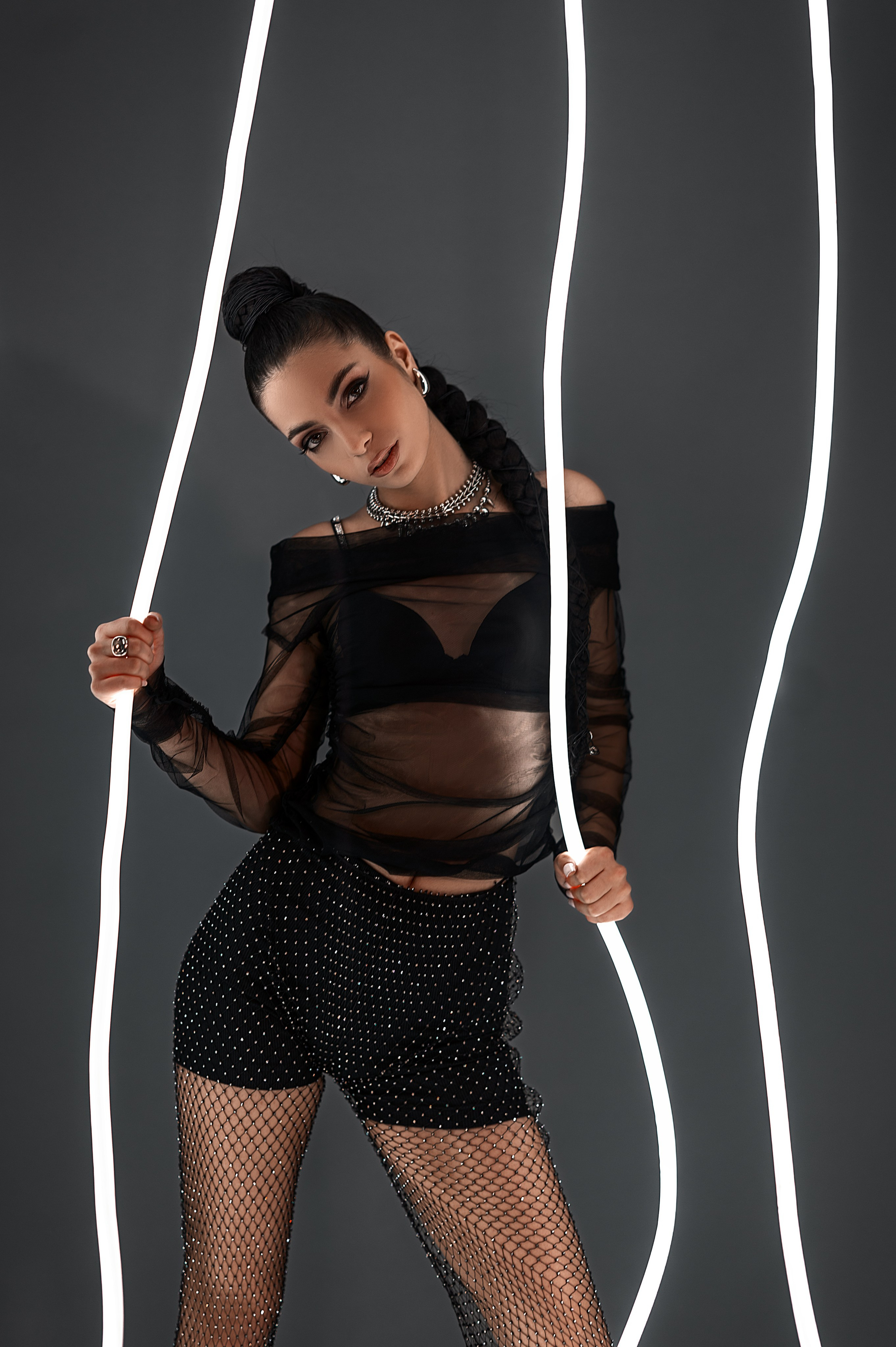 Студия в Волгодонске: фотосессия от Елизаветы Жуйковой. Модель в чёрной одежде, серый фон, неоновые детали — стильная постановочная съёмка.