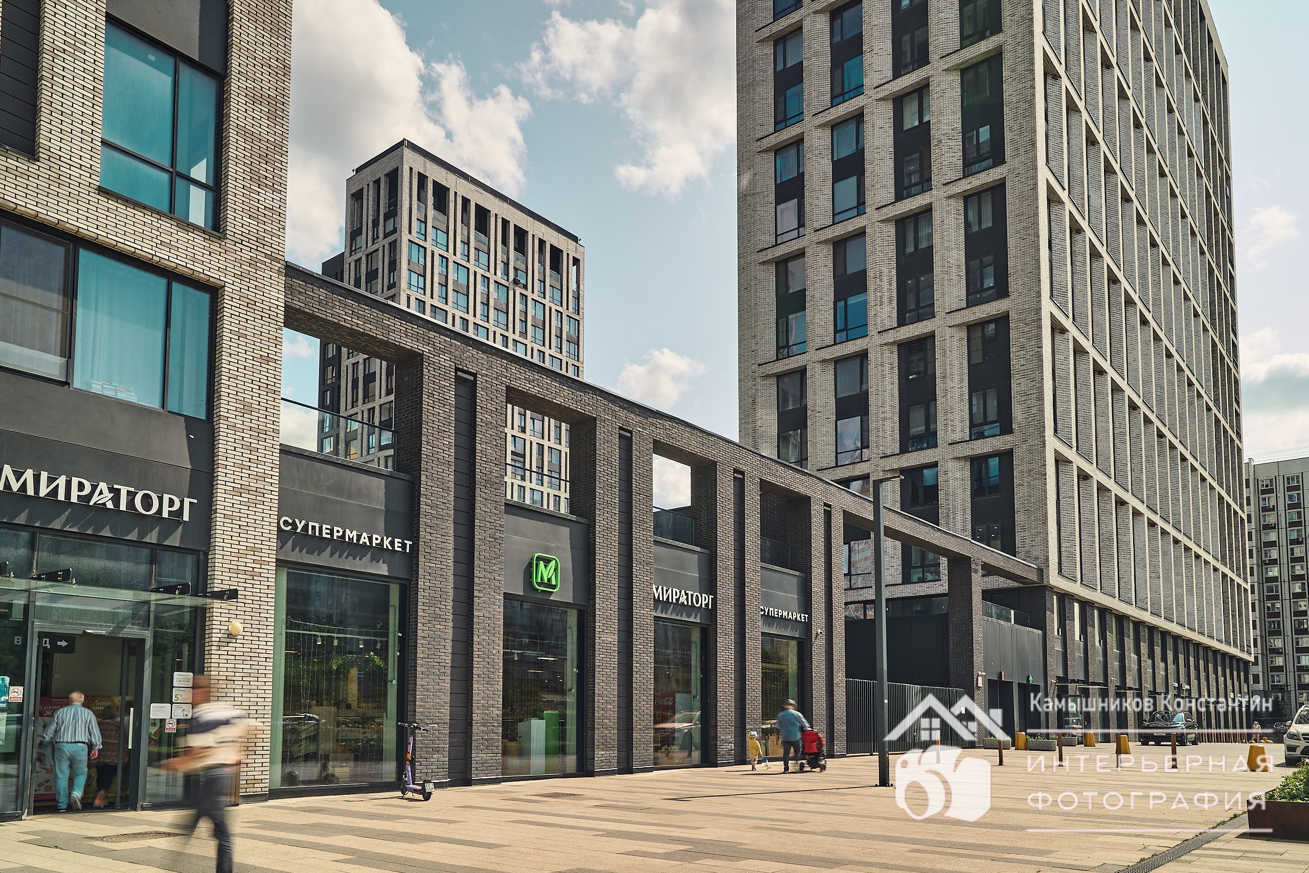 Архитектурное фото нескольких корпусов ЖК с супермаркетом на первом плане