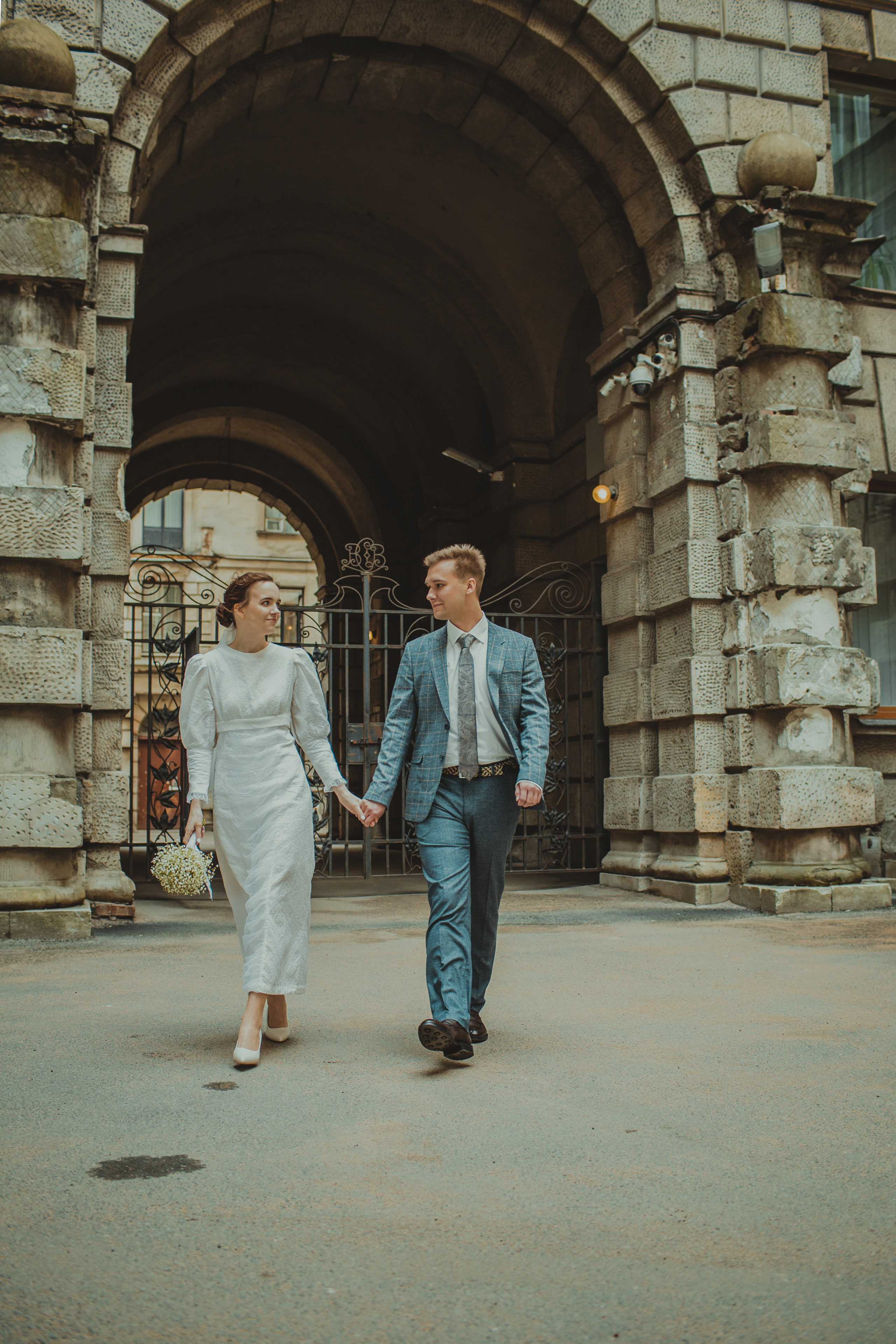 жених и невеста идут, держась за руку из двора дома эмира бухарского