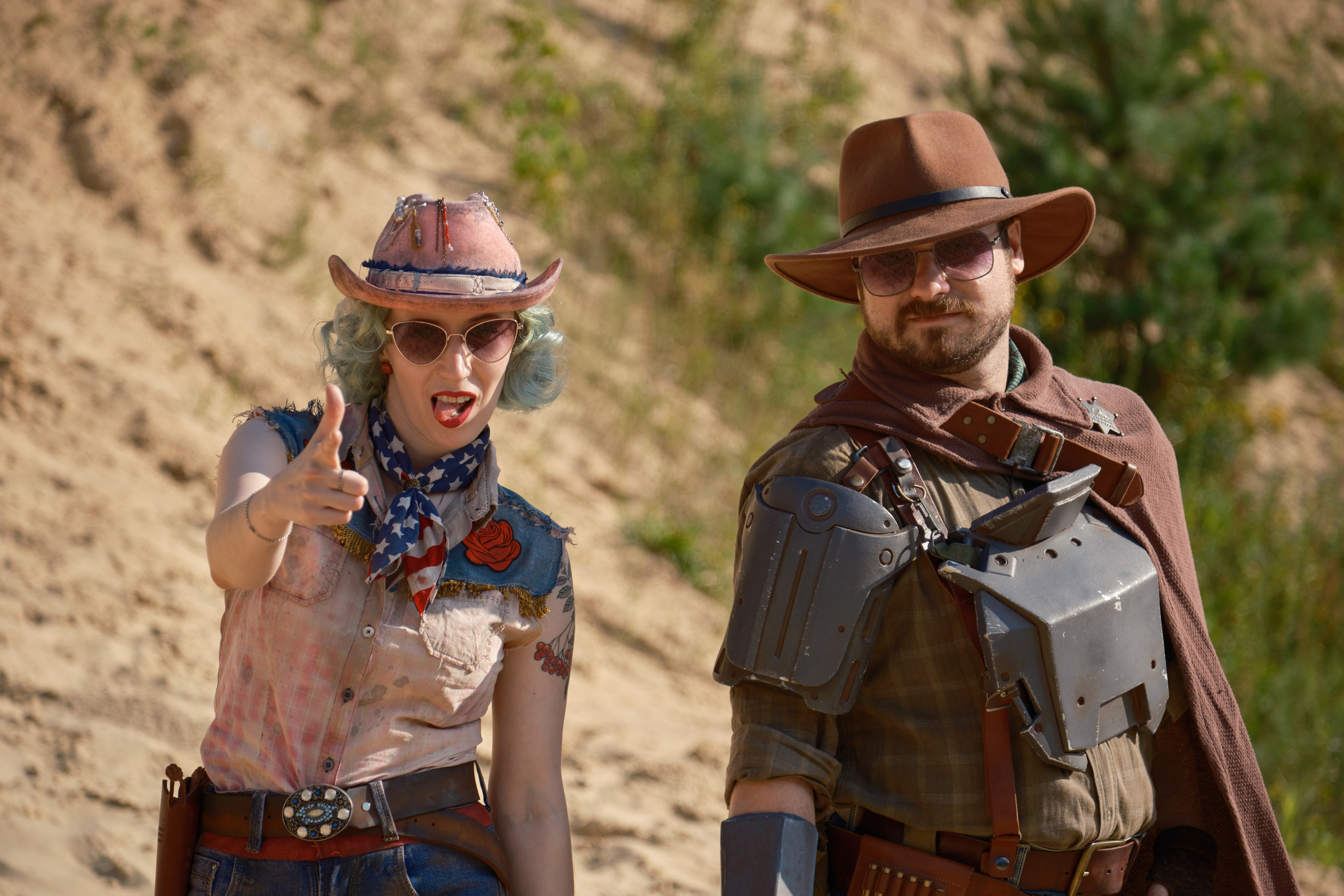 Мужчина и девушка в ковбойских шляпах и револьверами смотрят в камеру