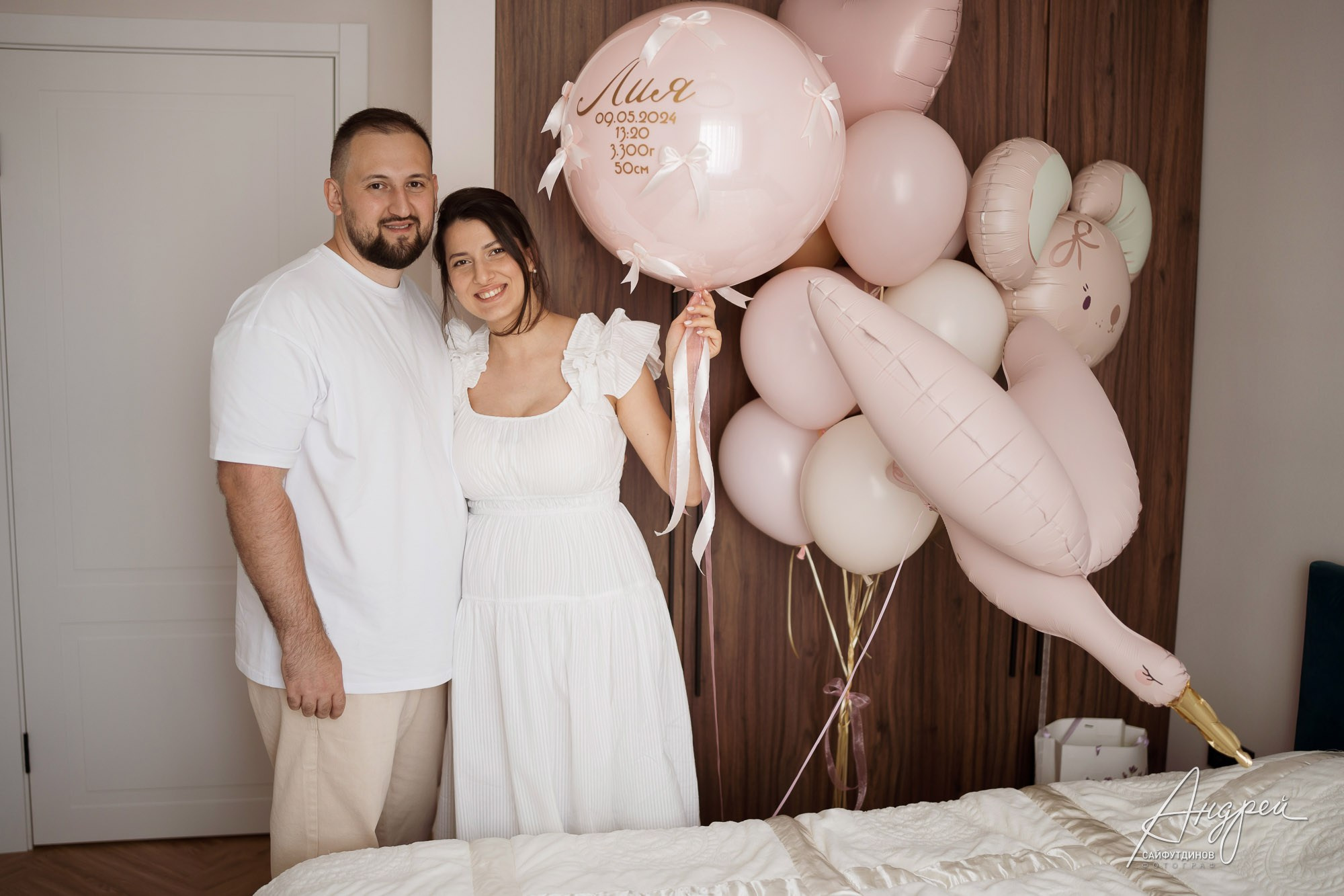 Молодые родители с новорожденной дочкой дома в Ростове-на-Дону в окружении розовых шаров, семейная фотосессия.