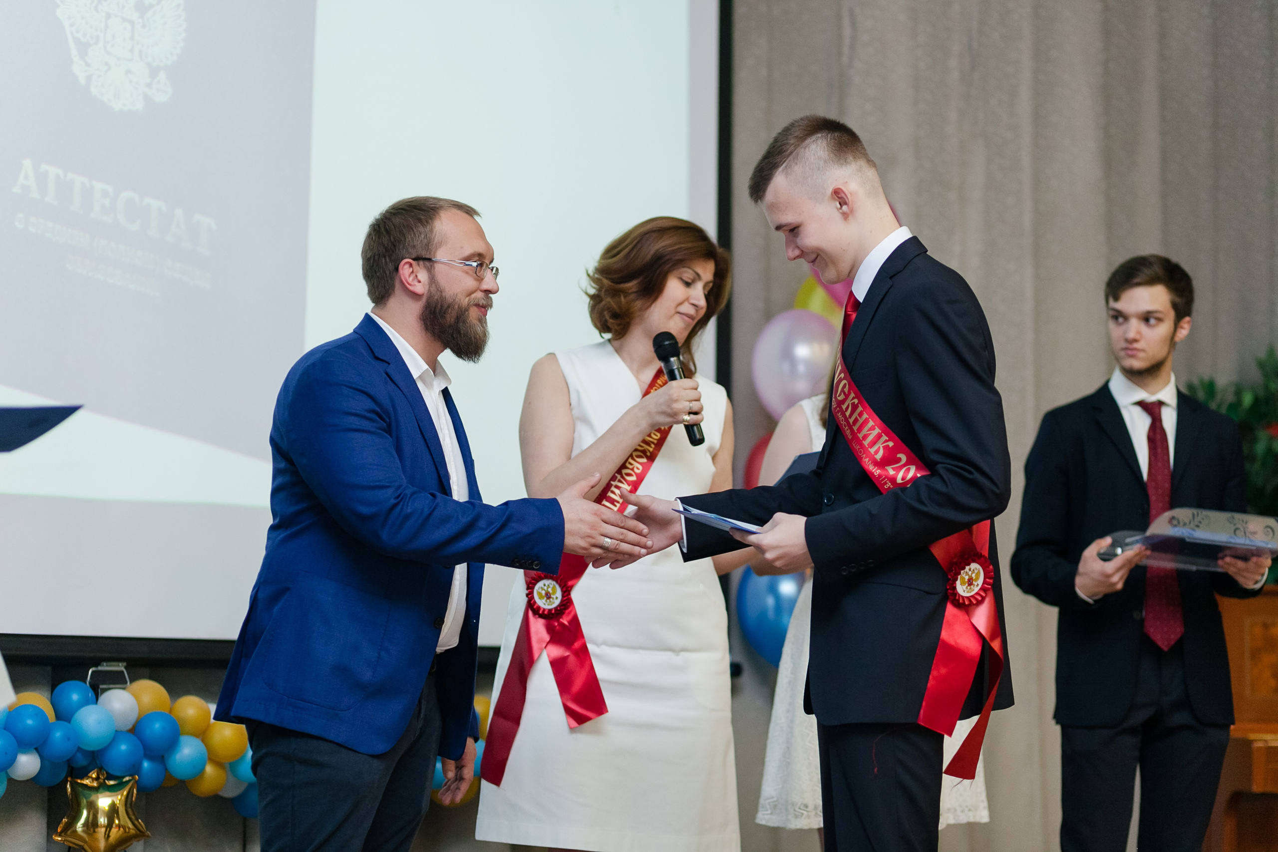 Директор школы награждает выпусника дипломом об окончании школы