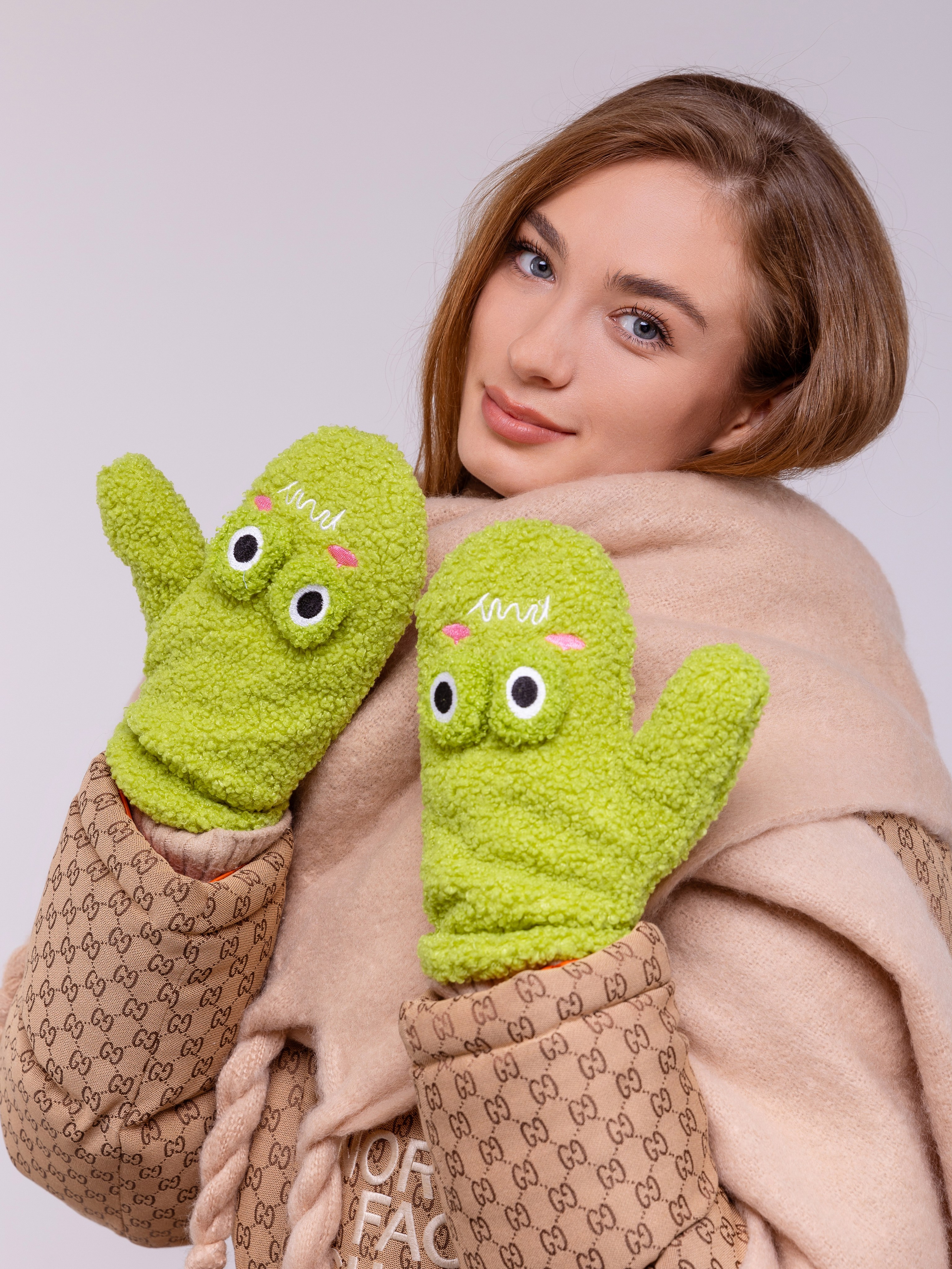 На зеленых рукавичках пришиты аппликациии в виде глаз.