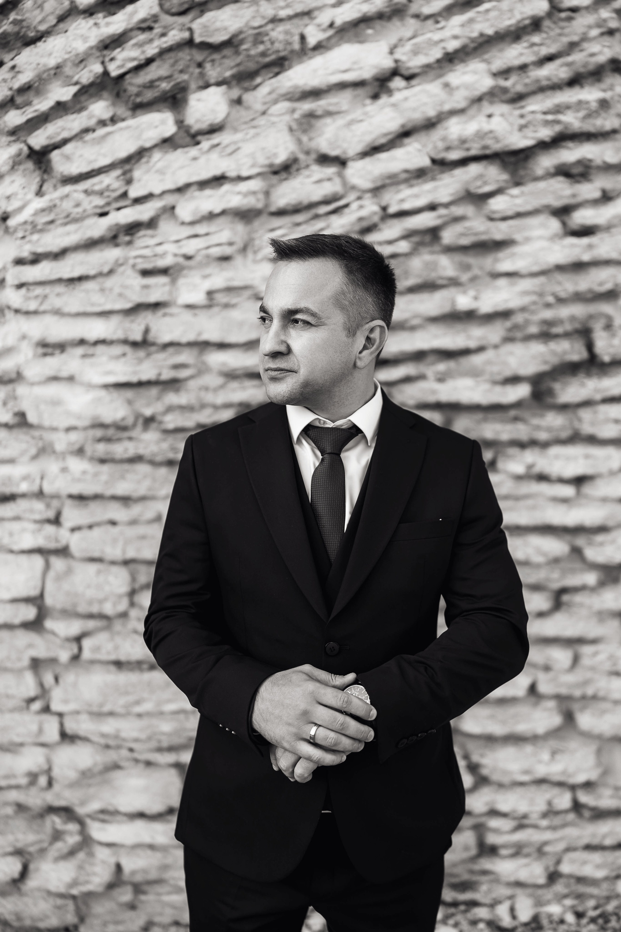 Жених поправляет часы возле стены. Фотограф Денис Перминов