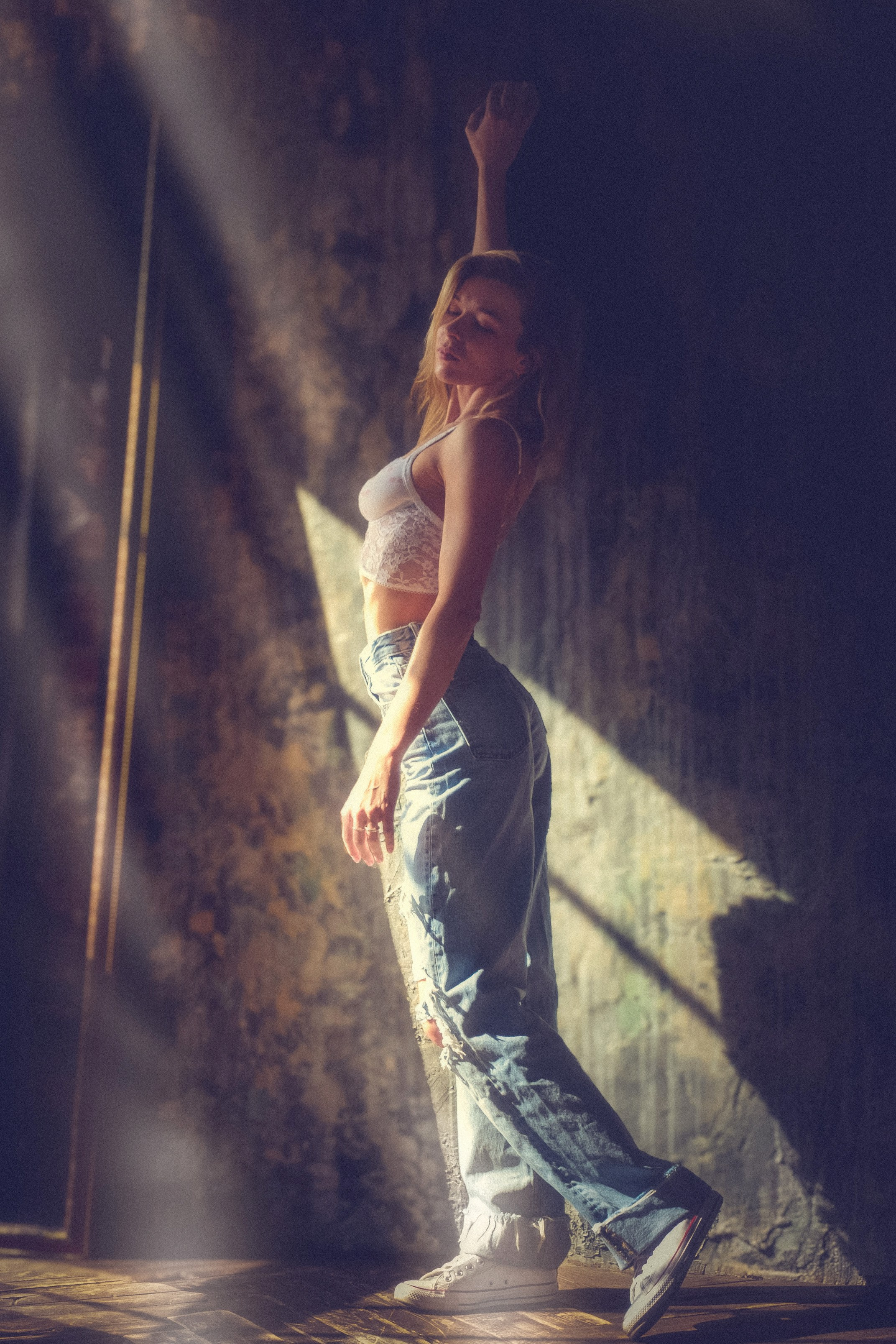 Грациозная походка девушки в джинсах и топе. Современная хореография, студийная фотосессия в стиле street-dance.