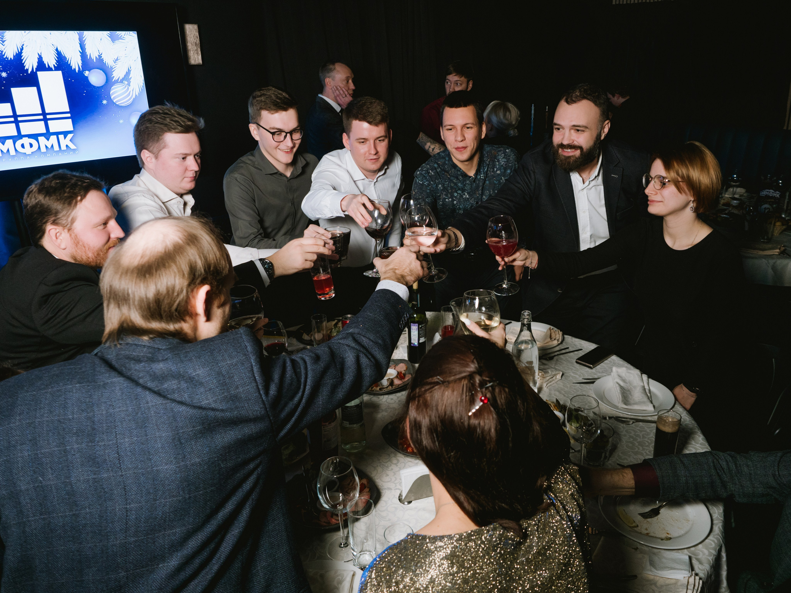 Фото сотрудники компании чокаются и произносят тост на корпоративе в лофте в Москве