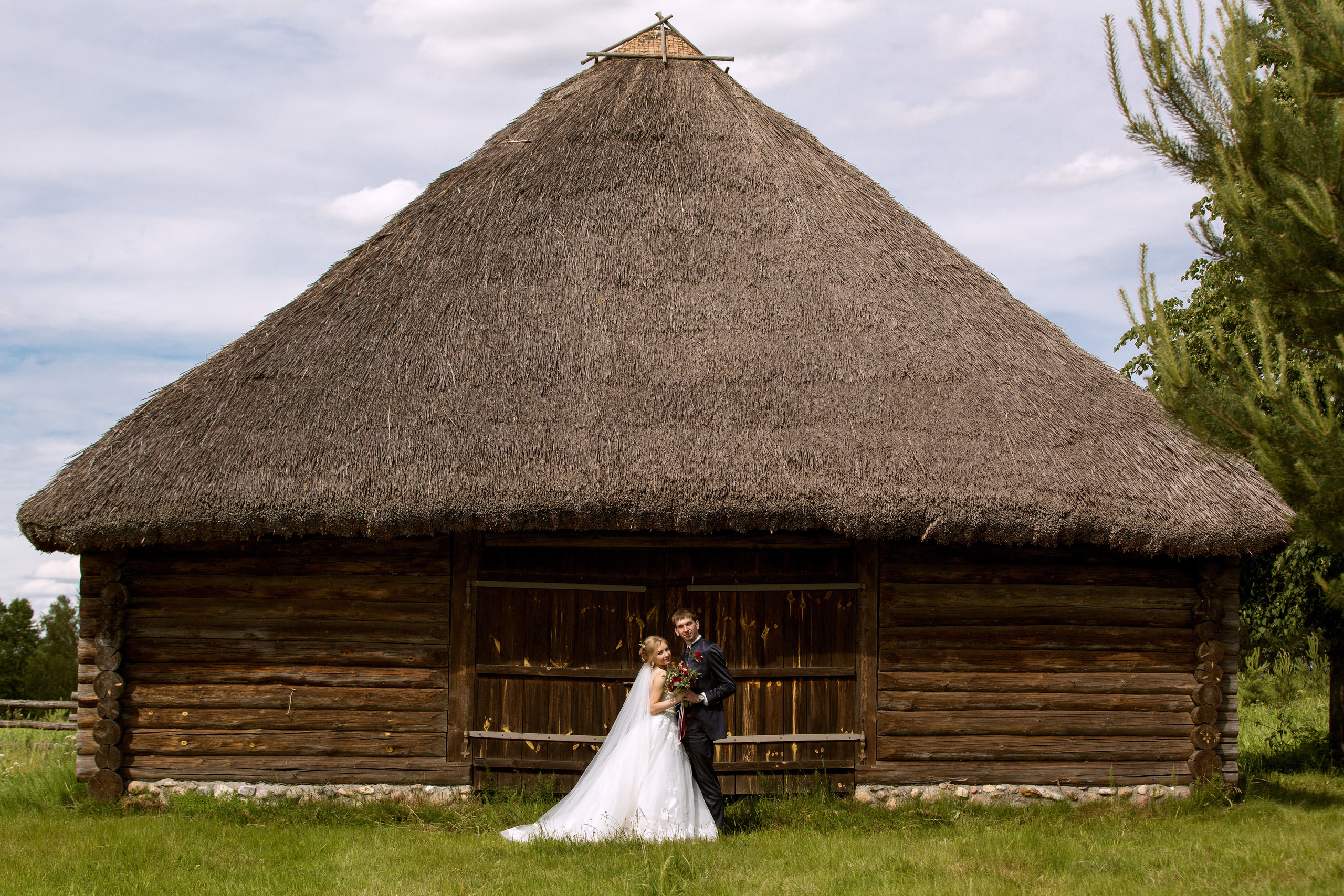 жених с невестой на фоне старинного деревянного домика