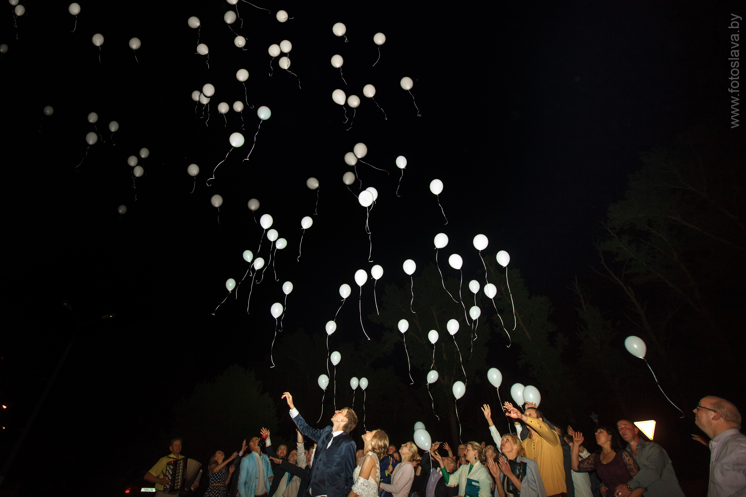 молодожены с гостями запускают белые шары