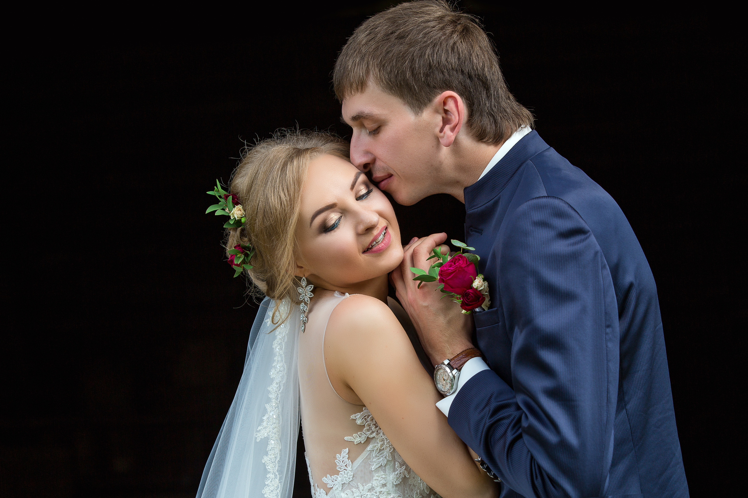 жених с невестой обнимаются на черном фоне