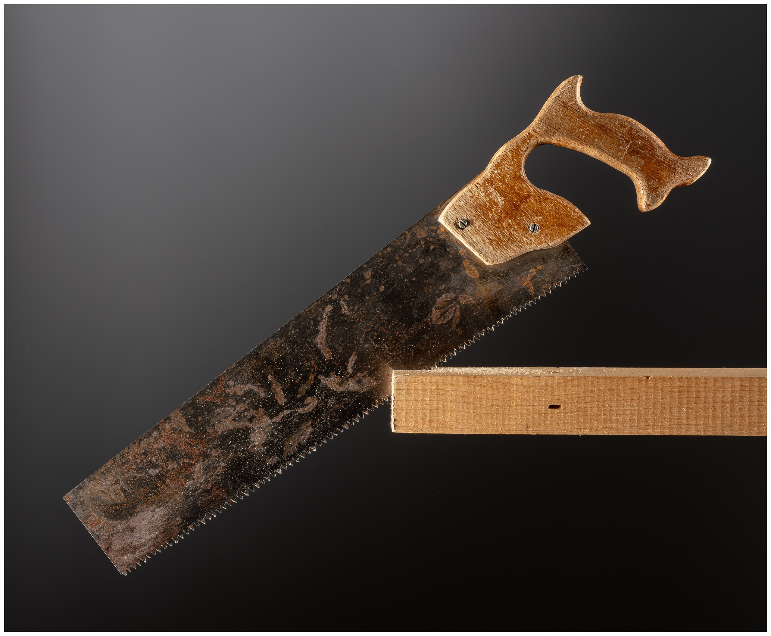 Старая ржавая ножовка с деревянной ручкой.