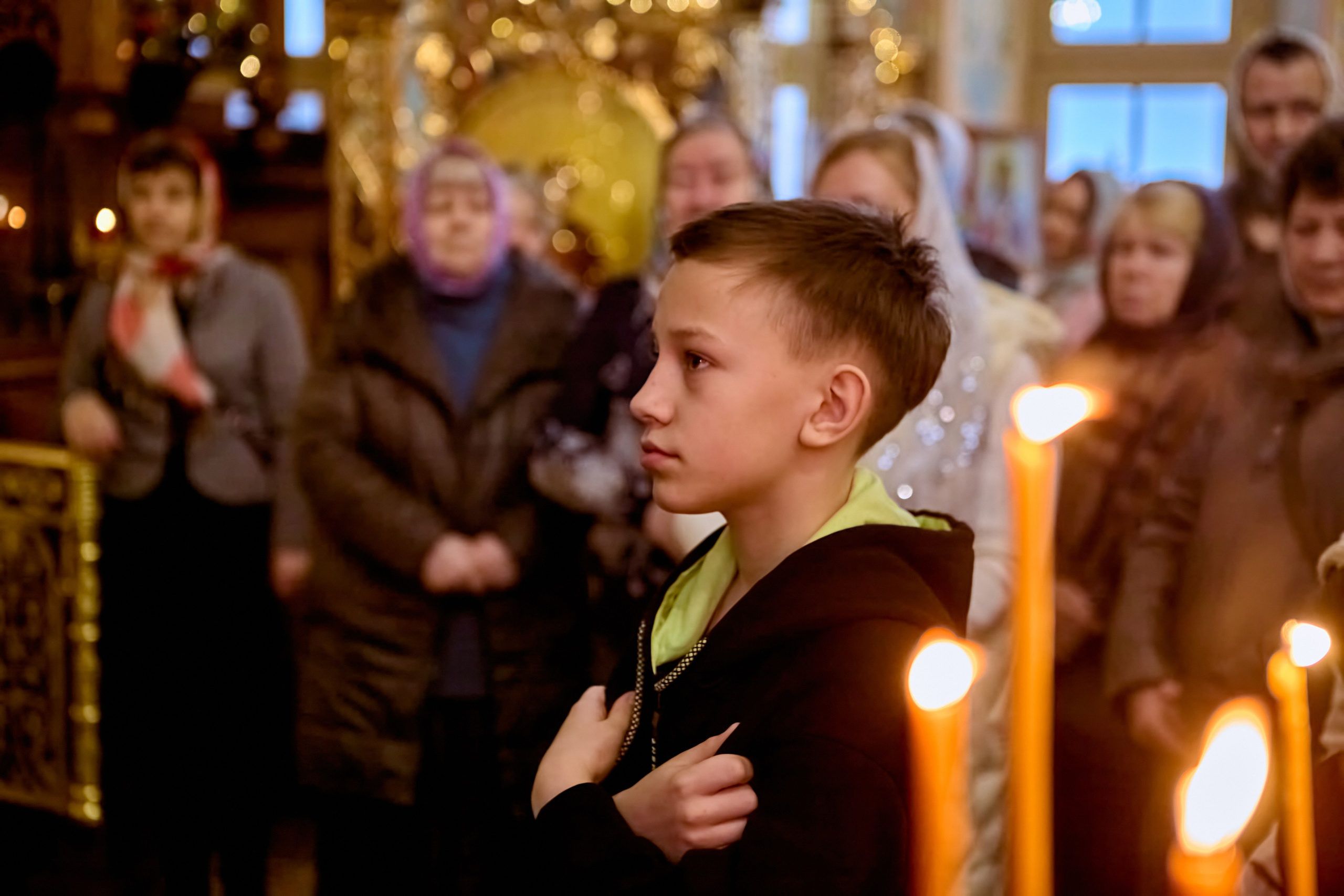 Мальчик 12-13 лет стоит со сложенными руками к причастию