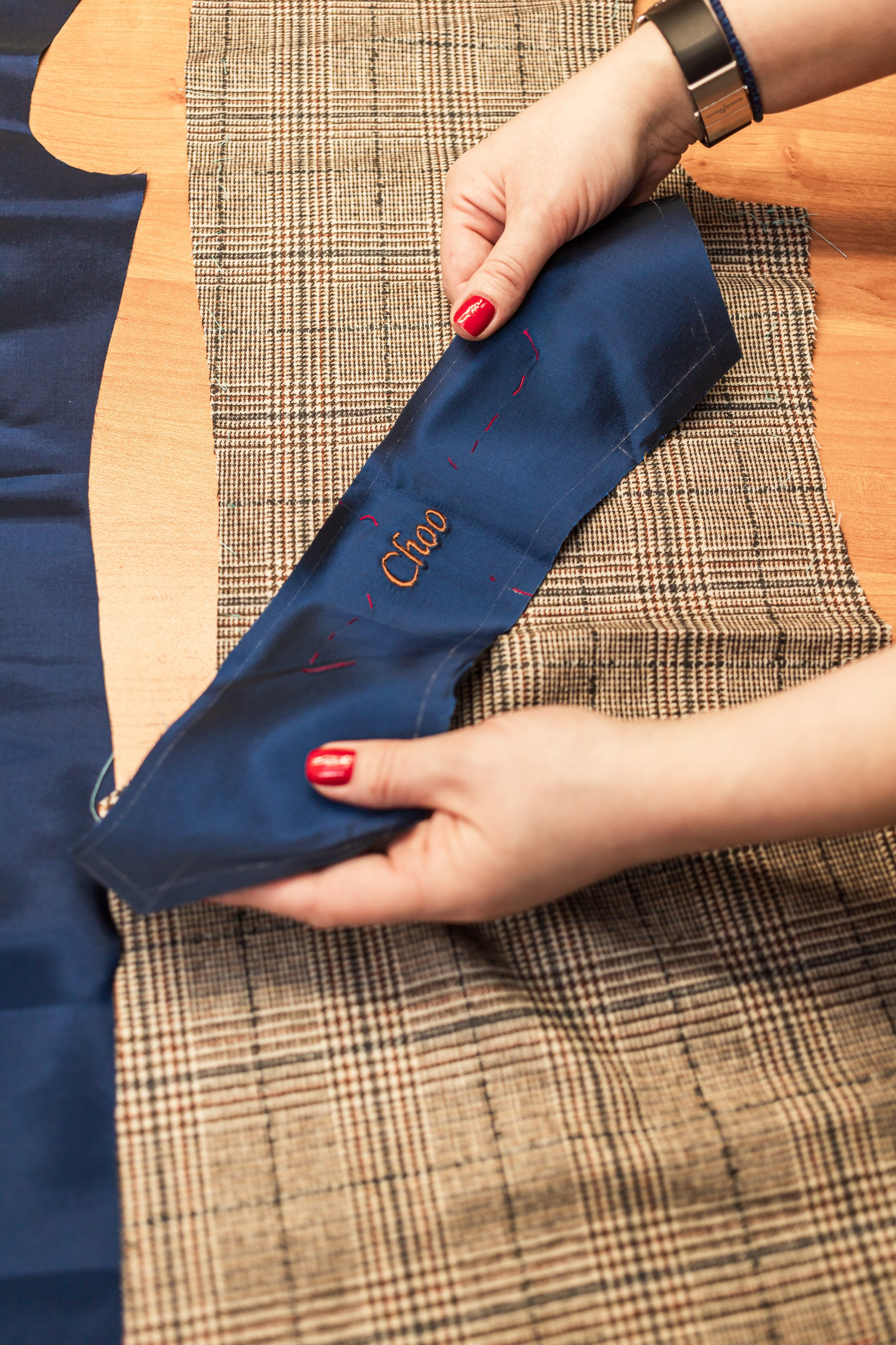 Деталь подкладки с вышитой фамилией клиента на клетчатой шерсти, ателье Natalia Chevdar, Екатеринбург, фотограф Илья Антропов