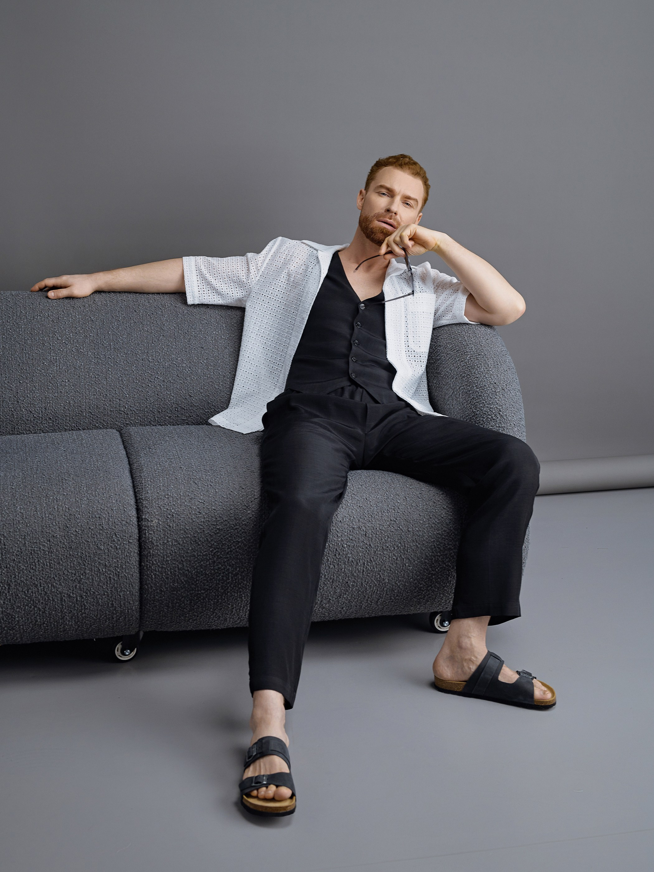 Мужчина модель в черной рубашке и черных брюках