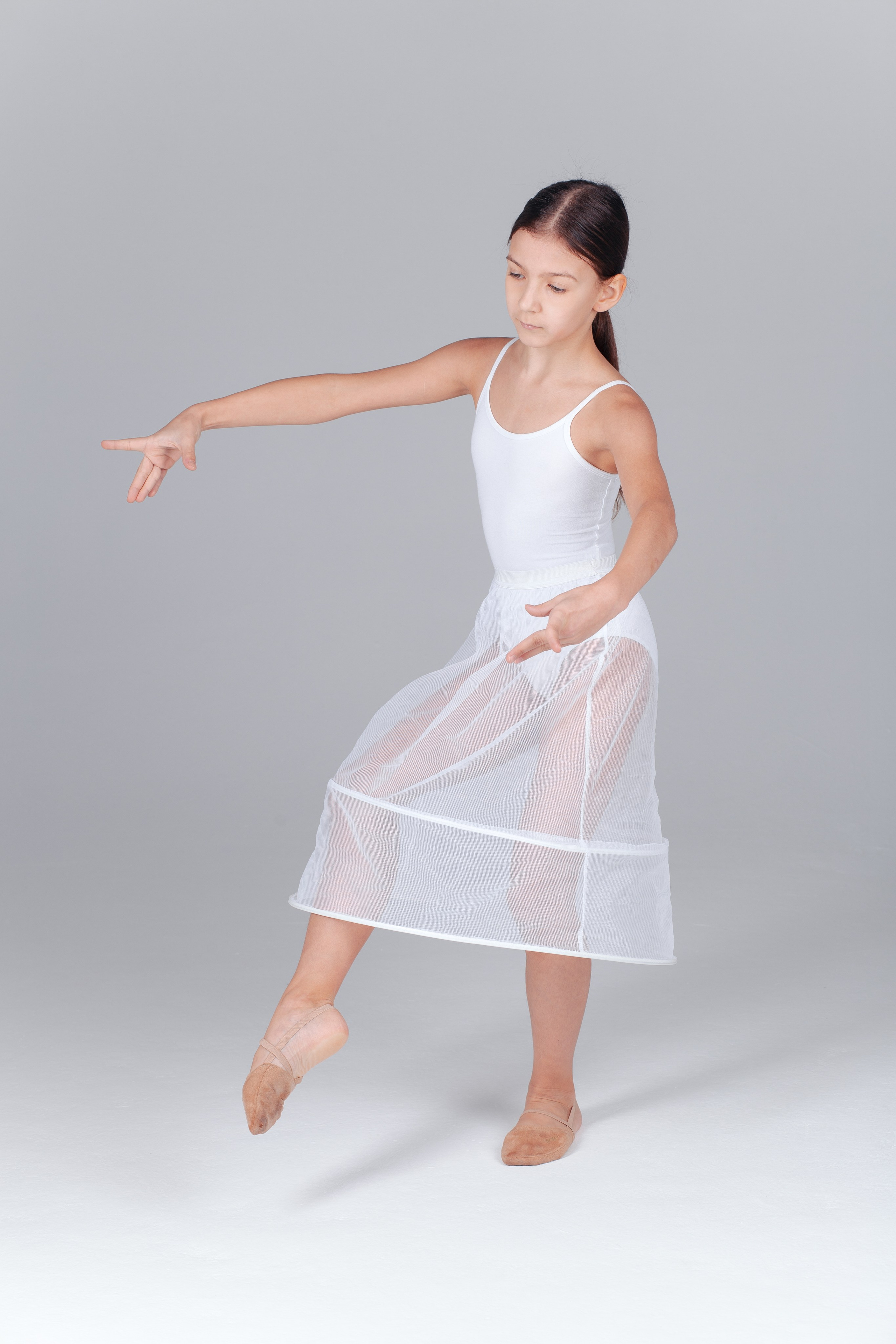 Девочка в белом купальнике и пачке танцует.