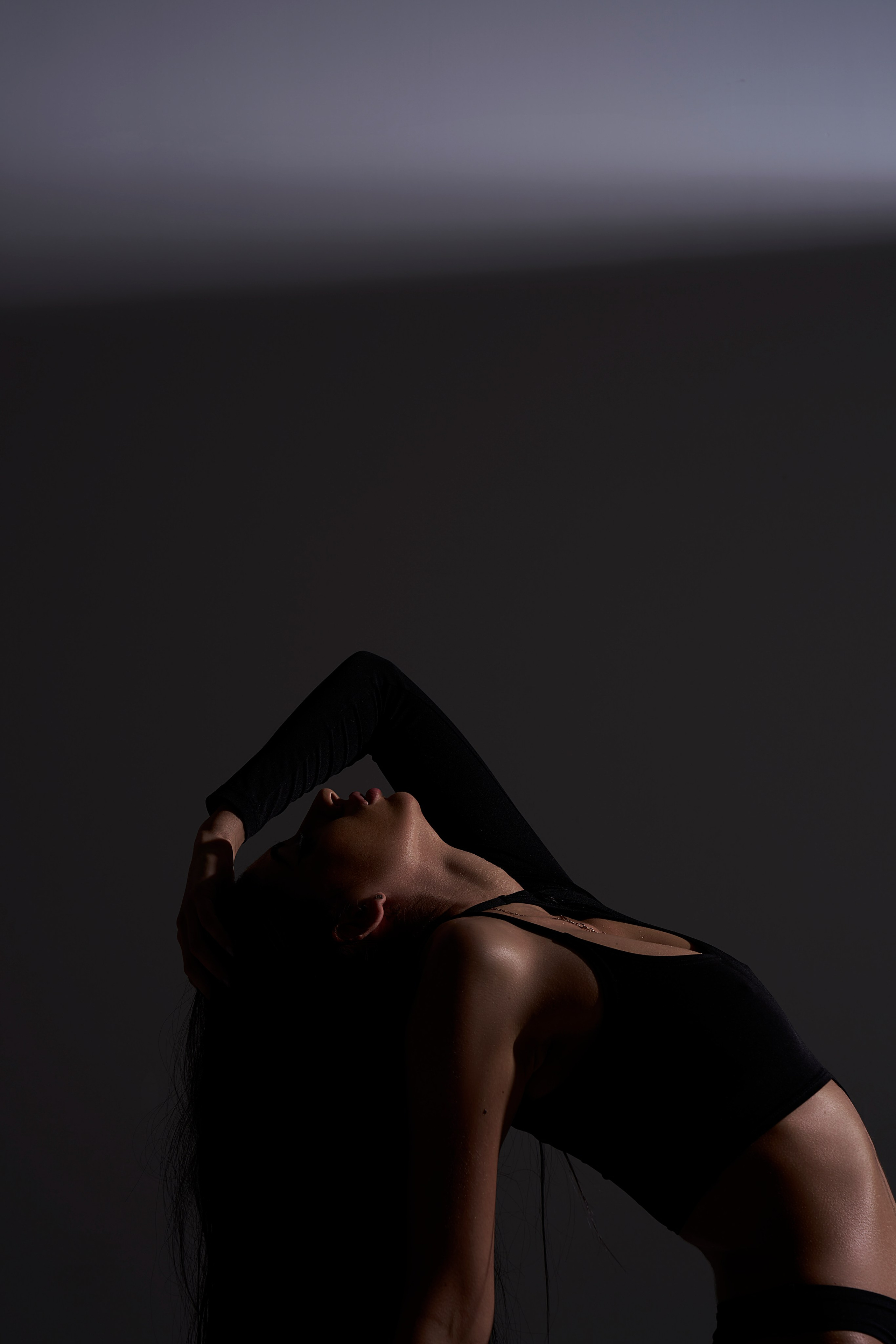 Ню-фотосессия в Москве: женская фигура в вытянутой позе, акцент на спину, архитектура света и тела