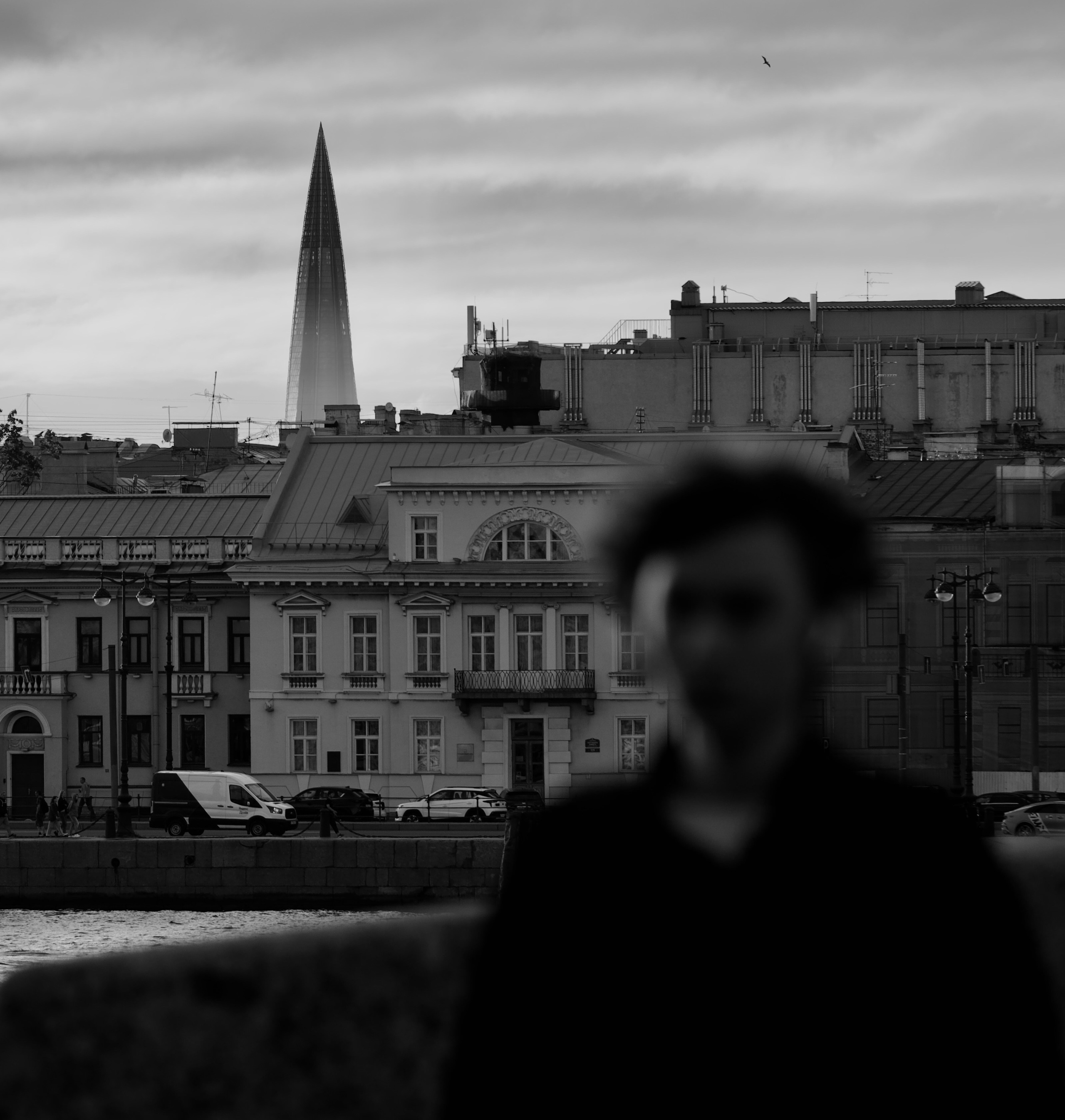 размытое лицо молодого человека и башня Лахта центра