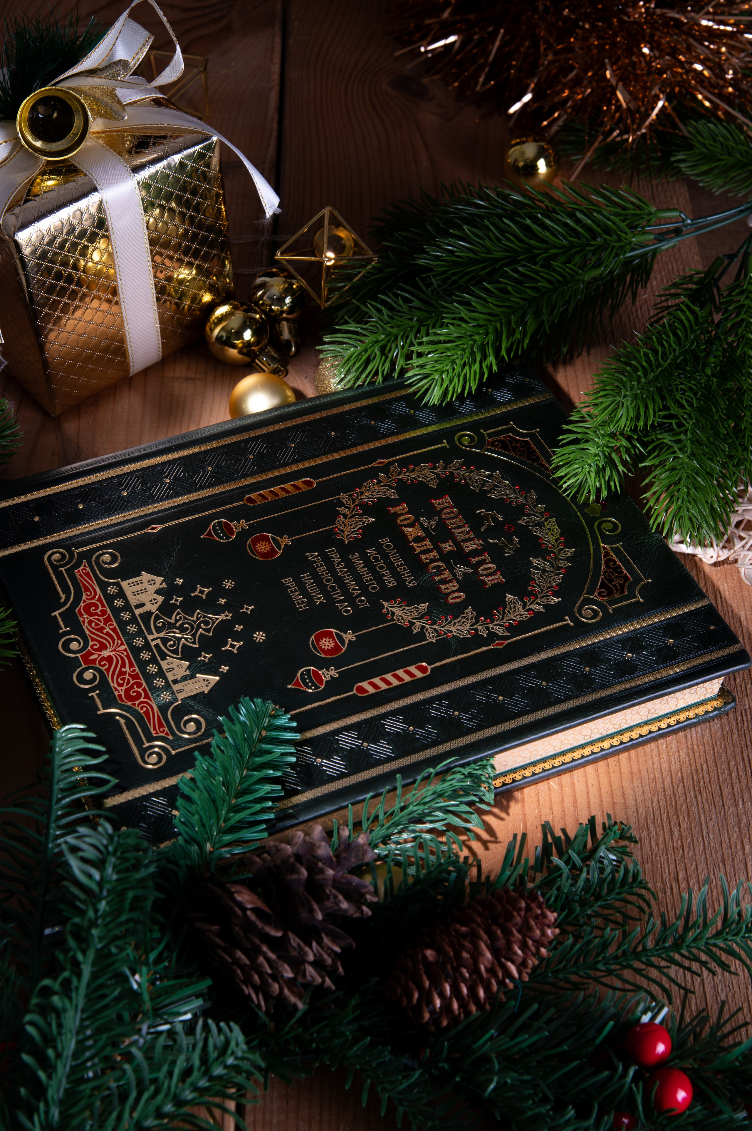 Концептуальная предметная фотосъёмка подарочной книги в новогодней композиции с еловыми ветками