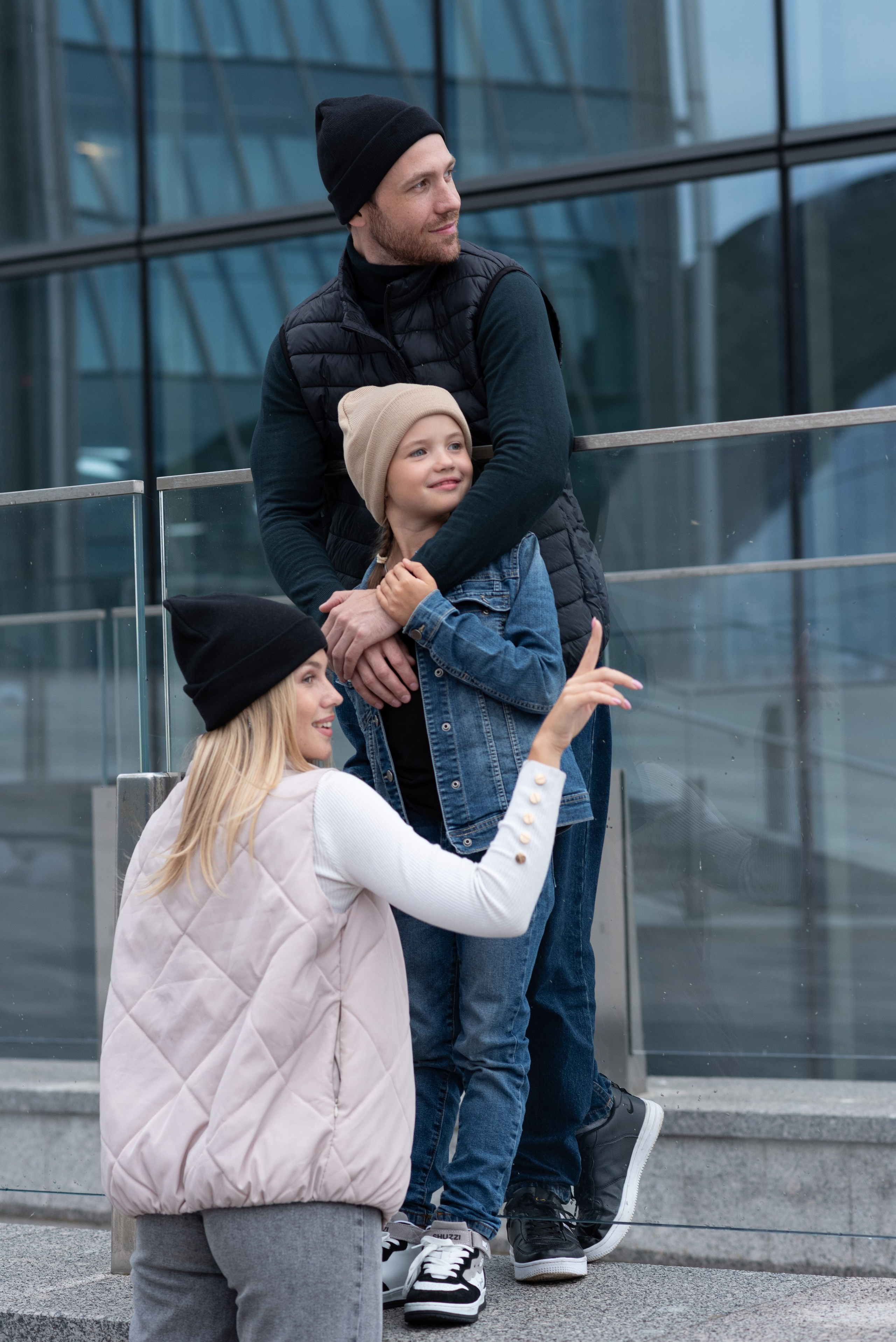 Девушка, мужчина и ребенок стоят в шапках