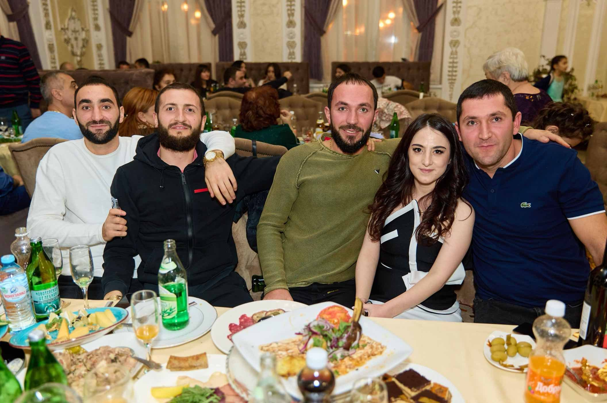 Пятеро гостей за длинным столом банкетного зала