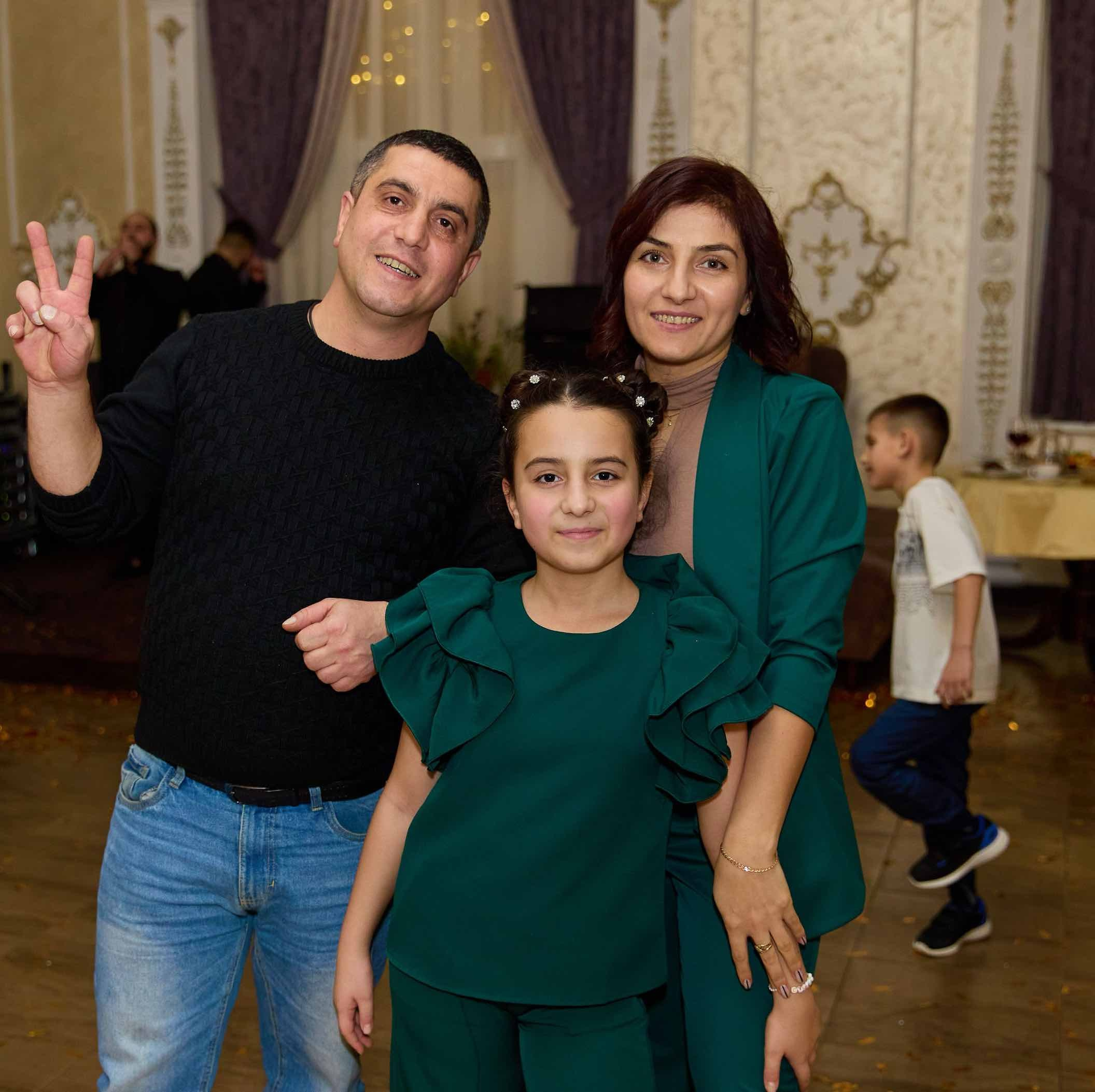 Родители с дочерью в зелёном, семейный портрет в зале