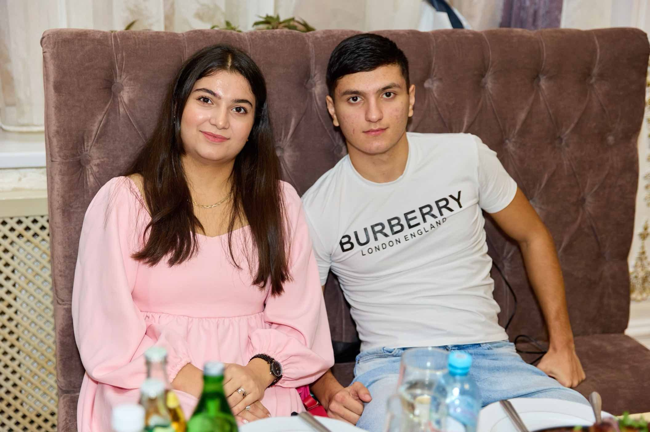 Молодая пара на диване у накрытого стола