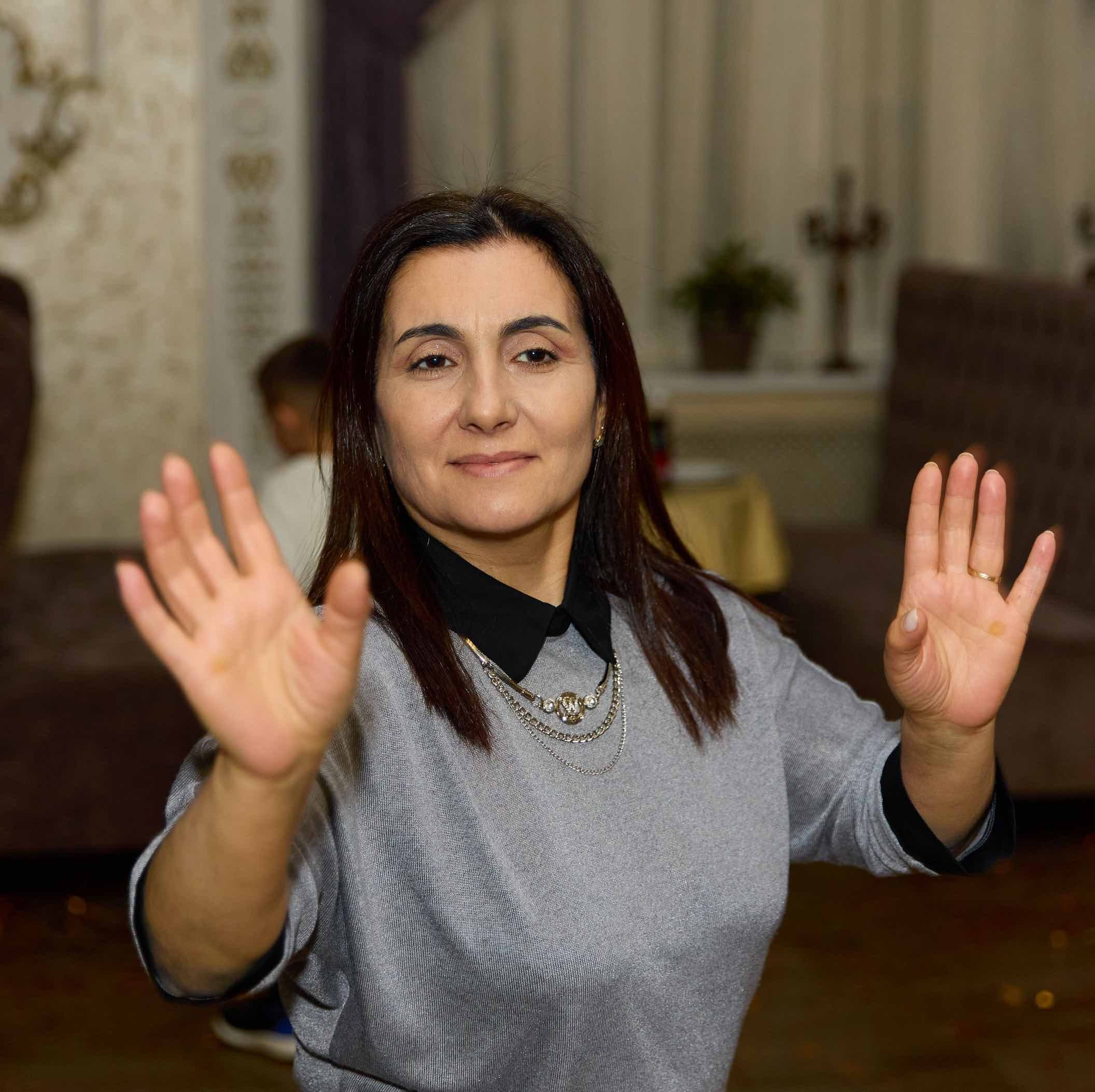 Гостья хлопает в ладоши в танце на годовасии