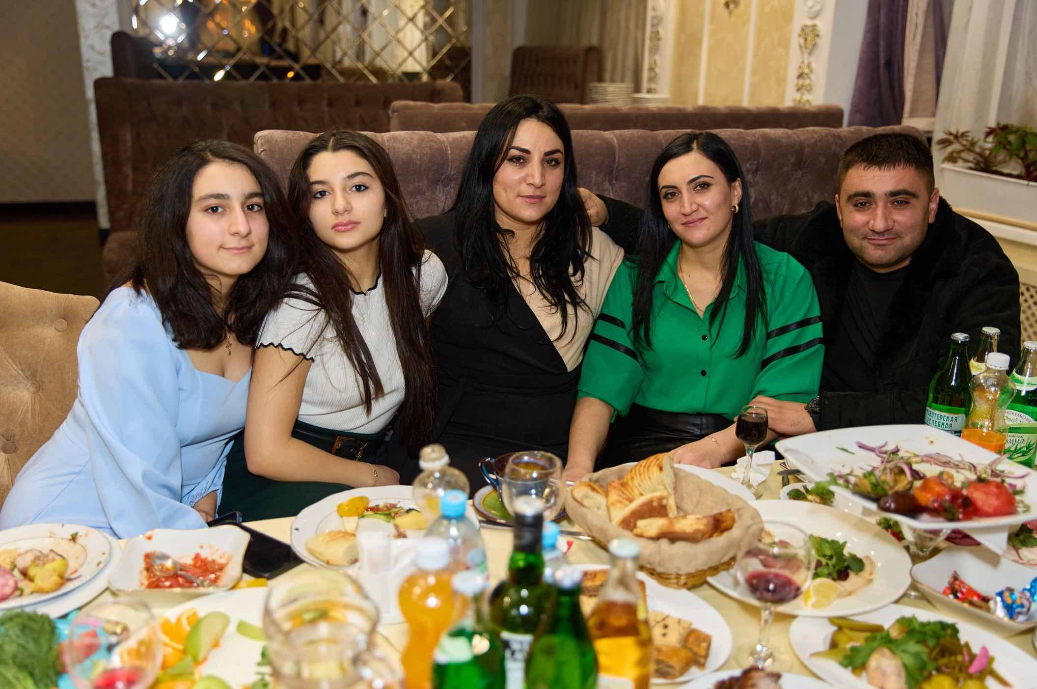 Пятеро гостей на диване за праздничным столом