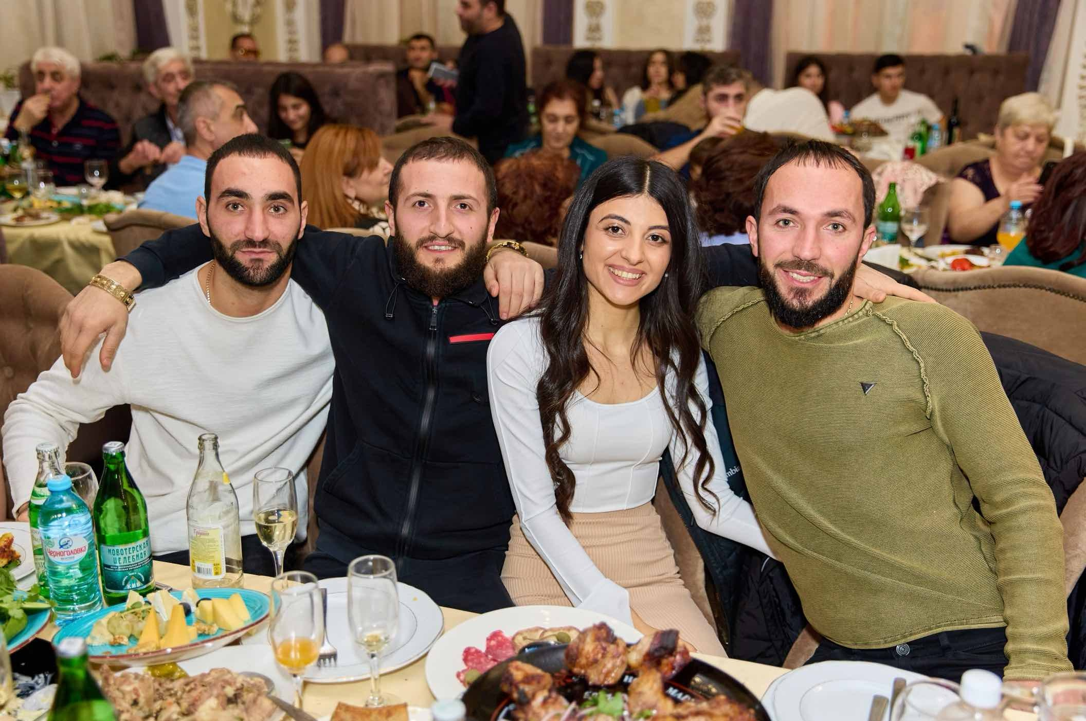 Компания молодых гостей за праздничным столом