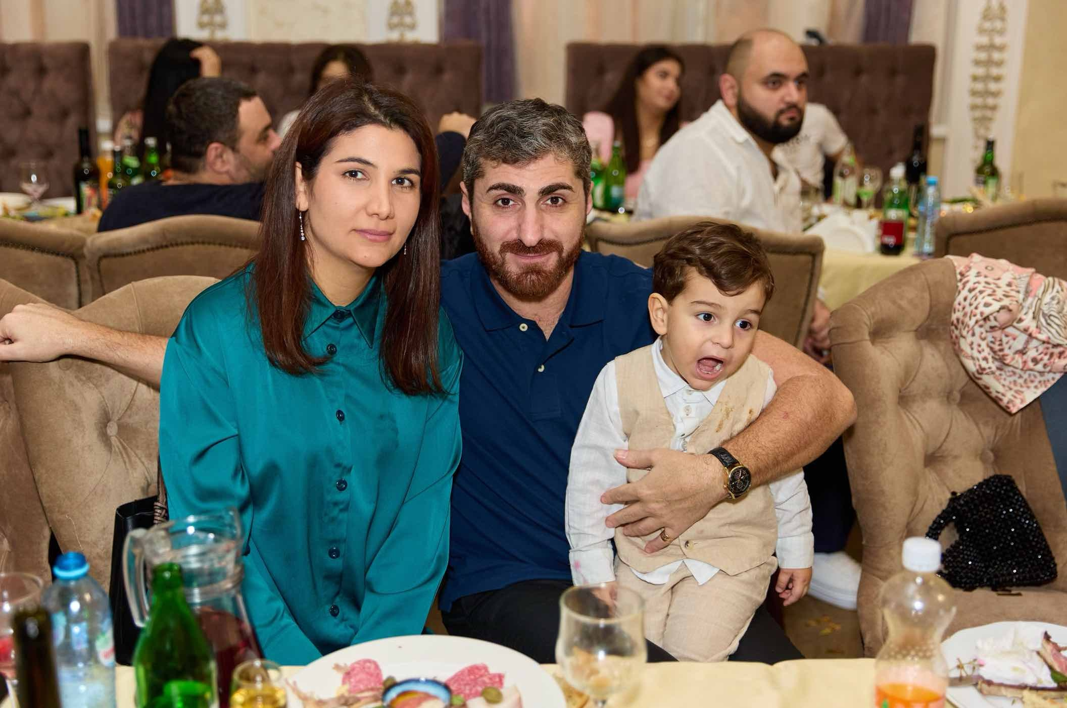 Родители с сыном за столом в зале