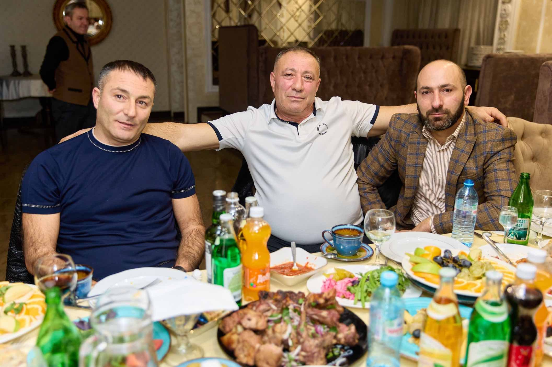 Трое гостей за праздничным столом ресторана