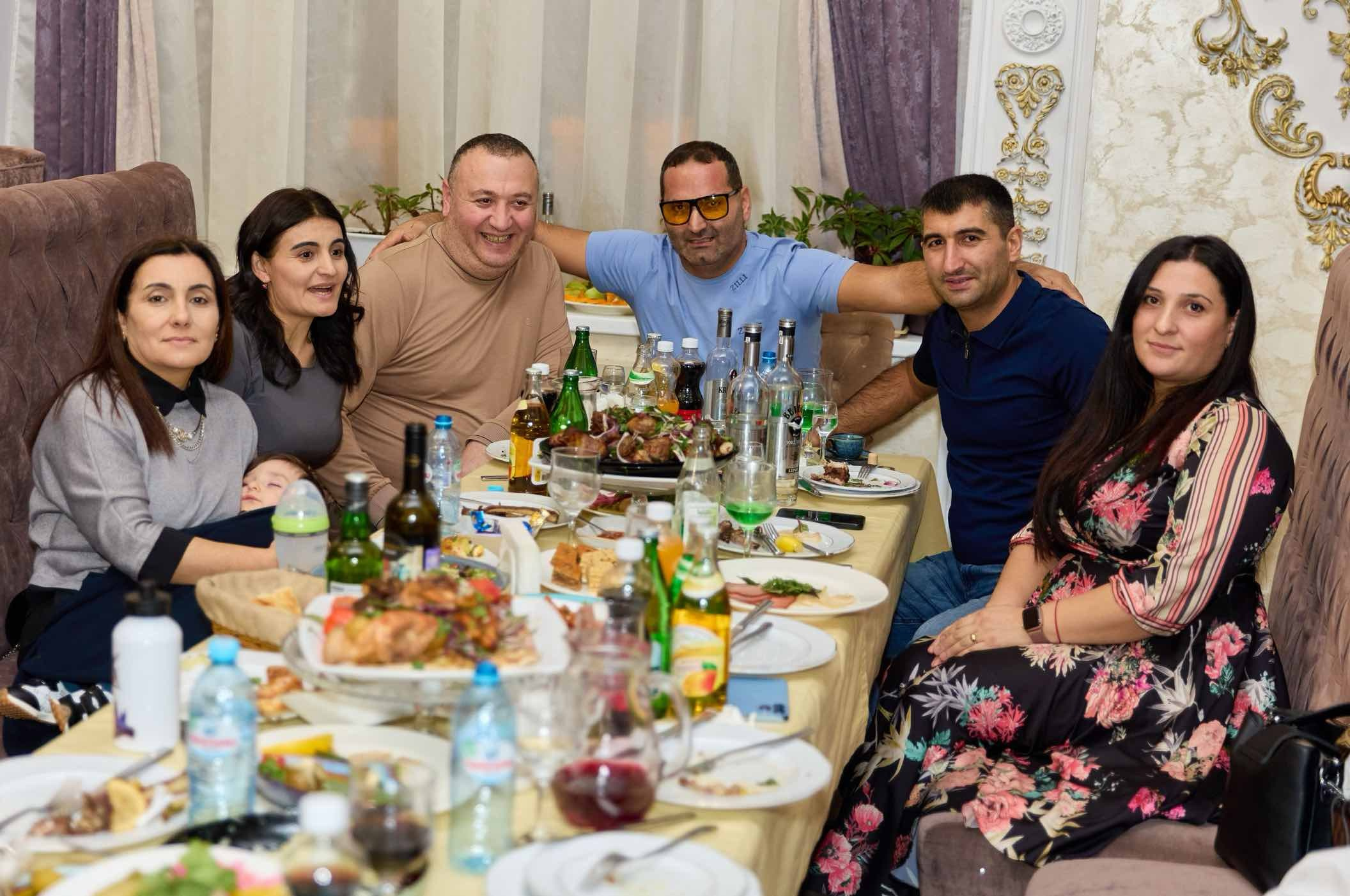 Компания гостей за накрытым столом ресторана