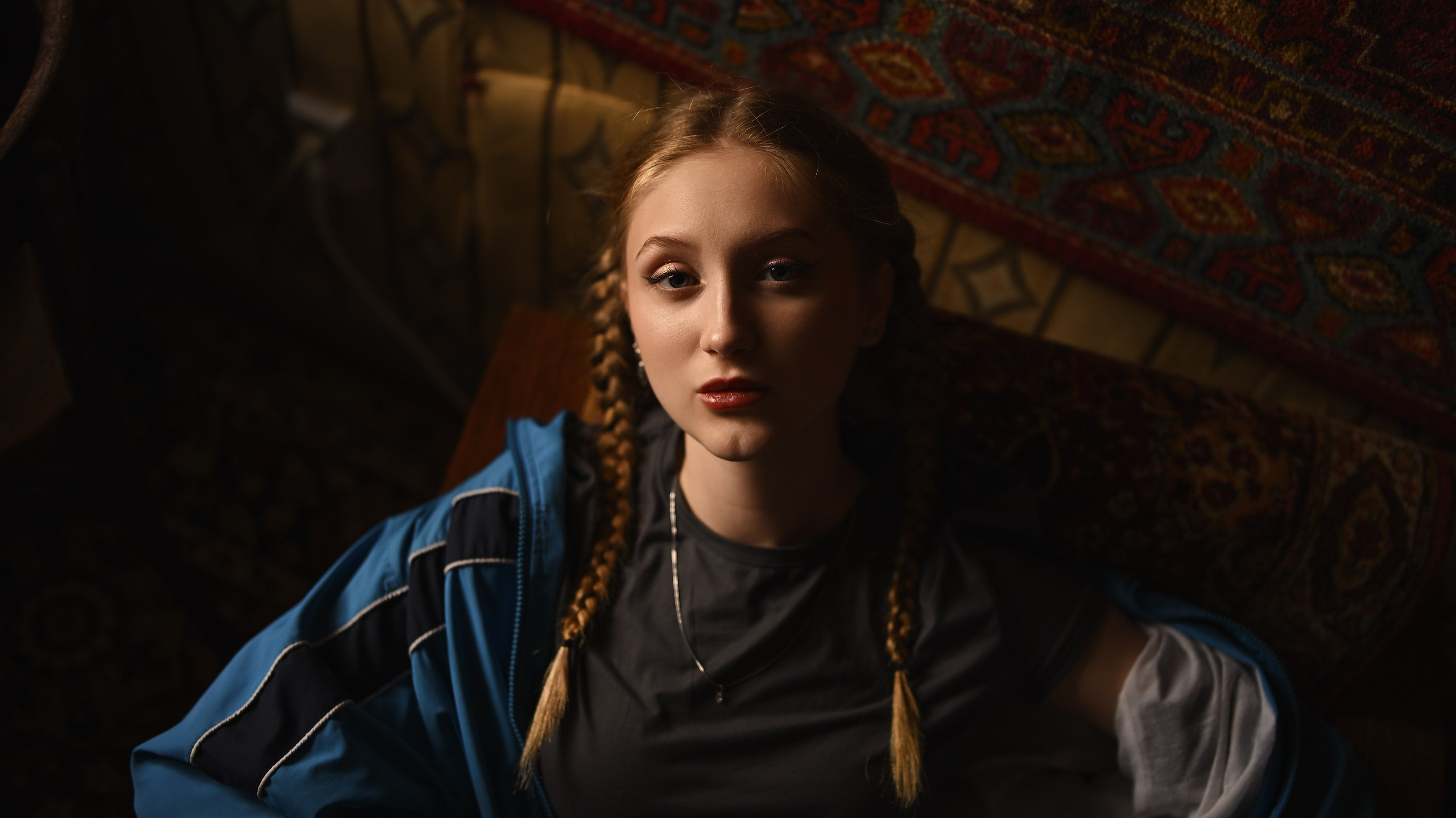 Девушка отдыхает на полу в интерьере советской квартиры с яркими коврами