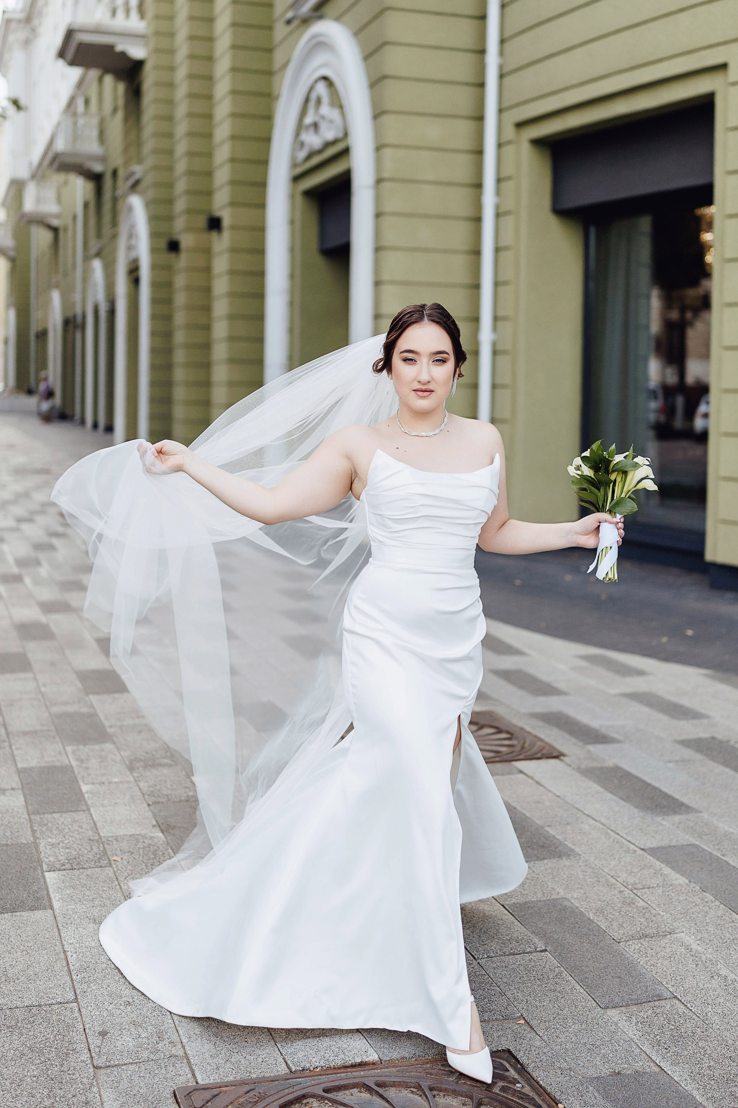 Невеста держит фату и гуляет в центре города Воронеж
