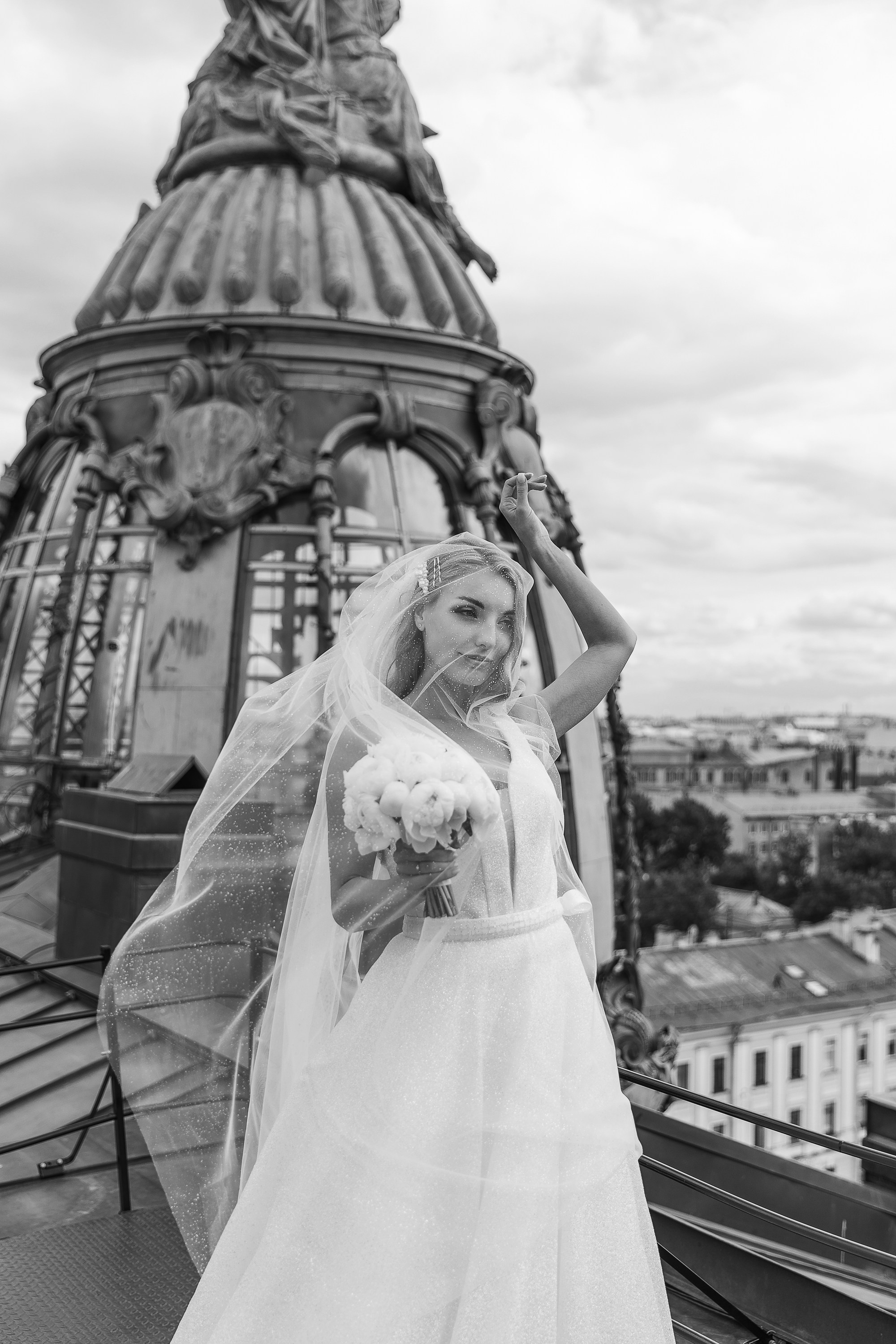 Невеста с фатой и букетом на крыше дома Зингер