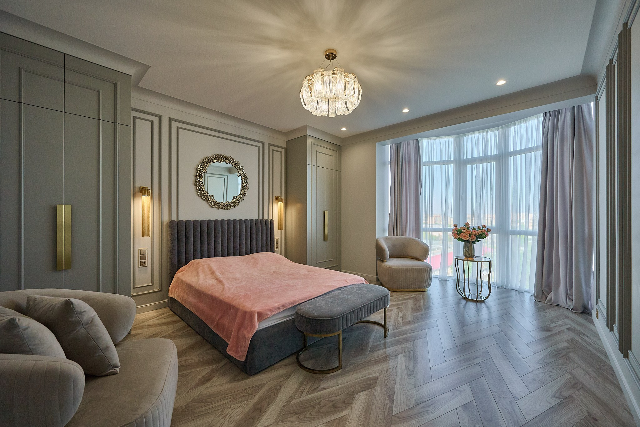 светлая комната с темно синем диваном и розовым пледом серым шкафом 