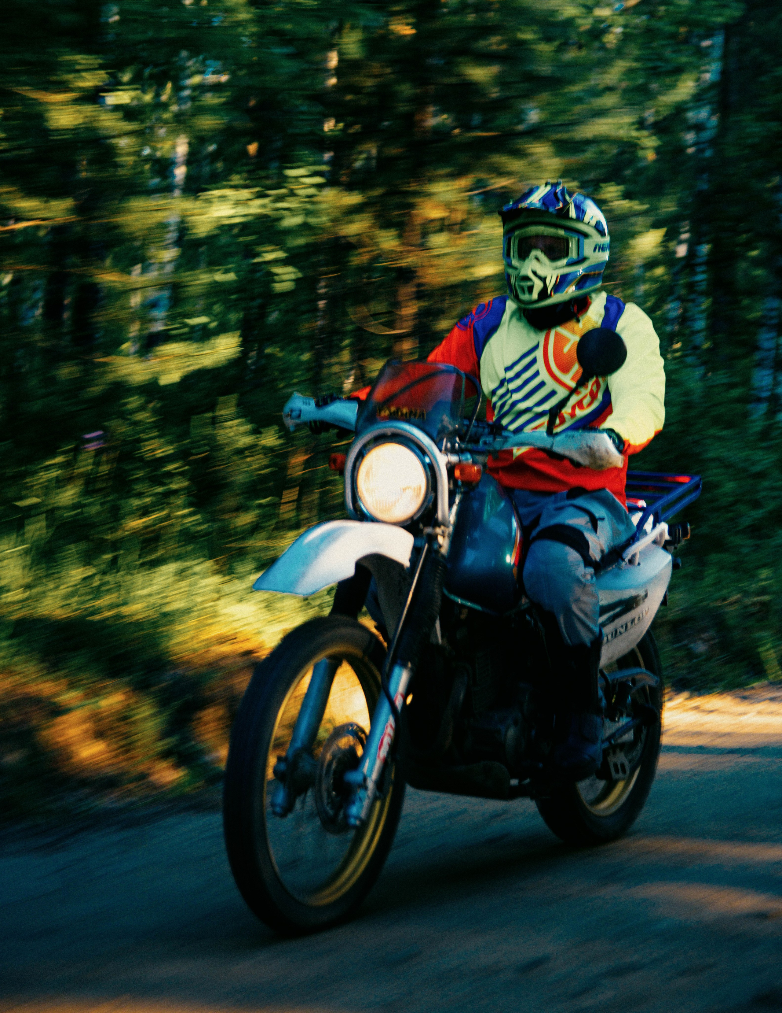 Мотоциклист эндуро едет по просёлочной грунтовой дороге