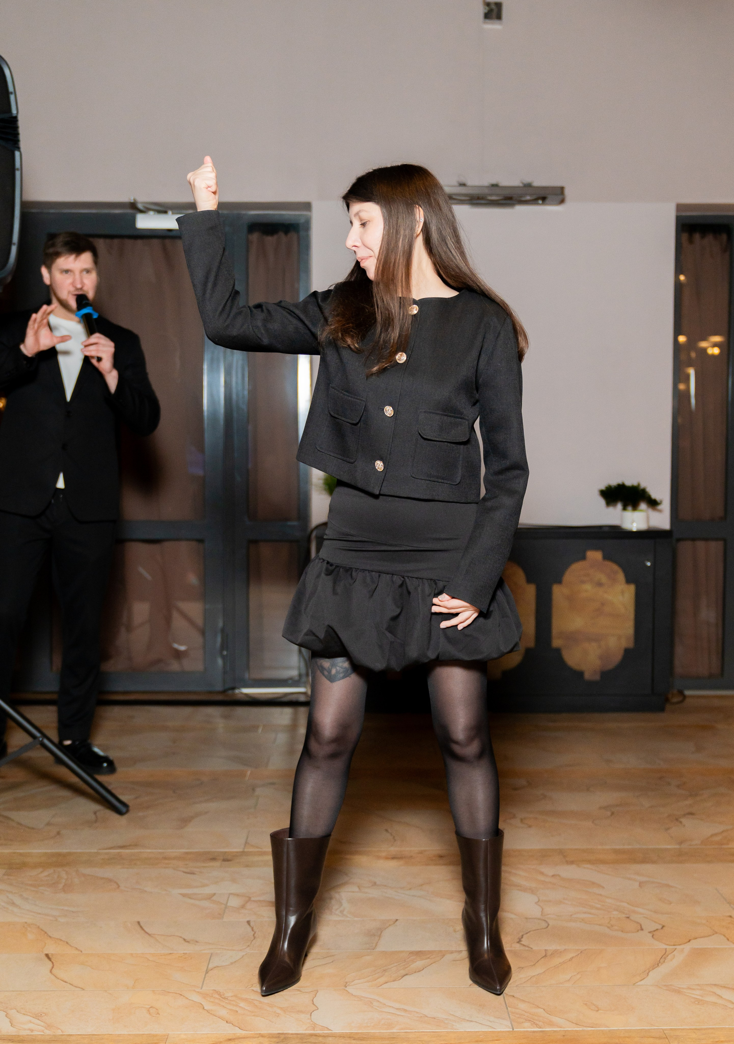 Гости улыбаются и общаются за высоким столом на фуршете в Radisson Sonya. Женщина в чёрном платье с белым воротником и женщина в чёрном жакете. Фотограф Евгений Мальцев