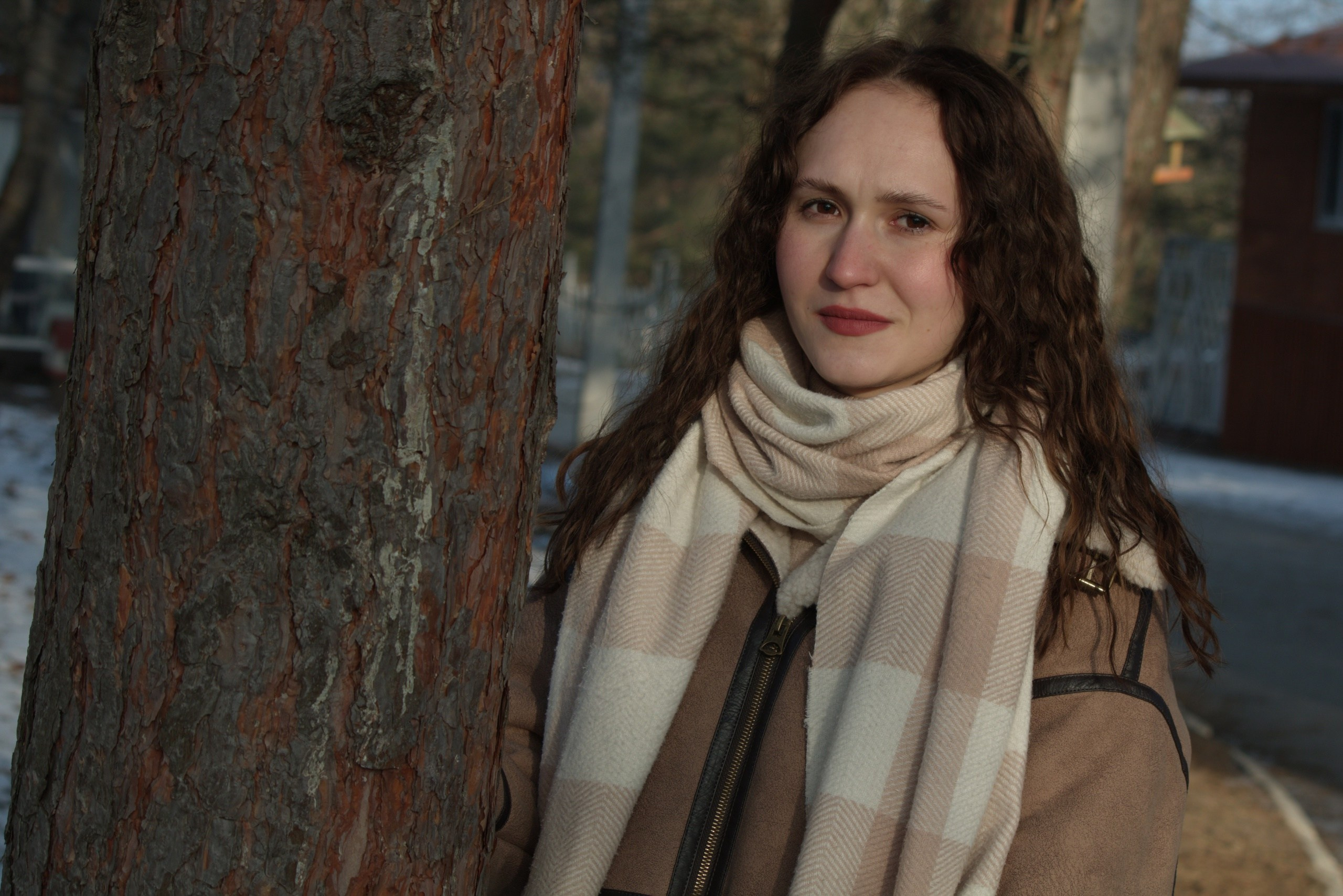 женский портрет крупным планом у дерева