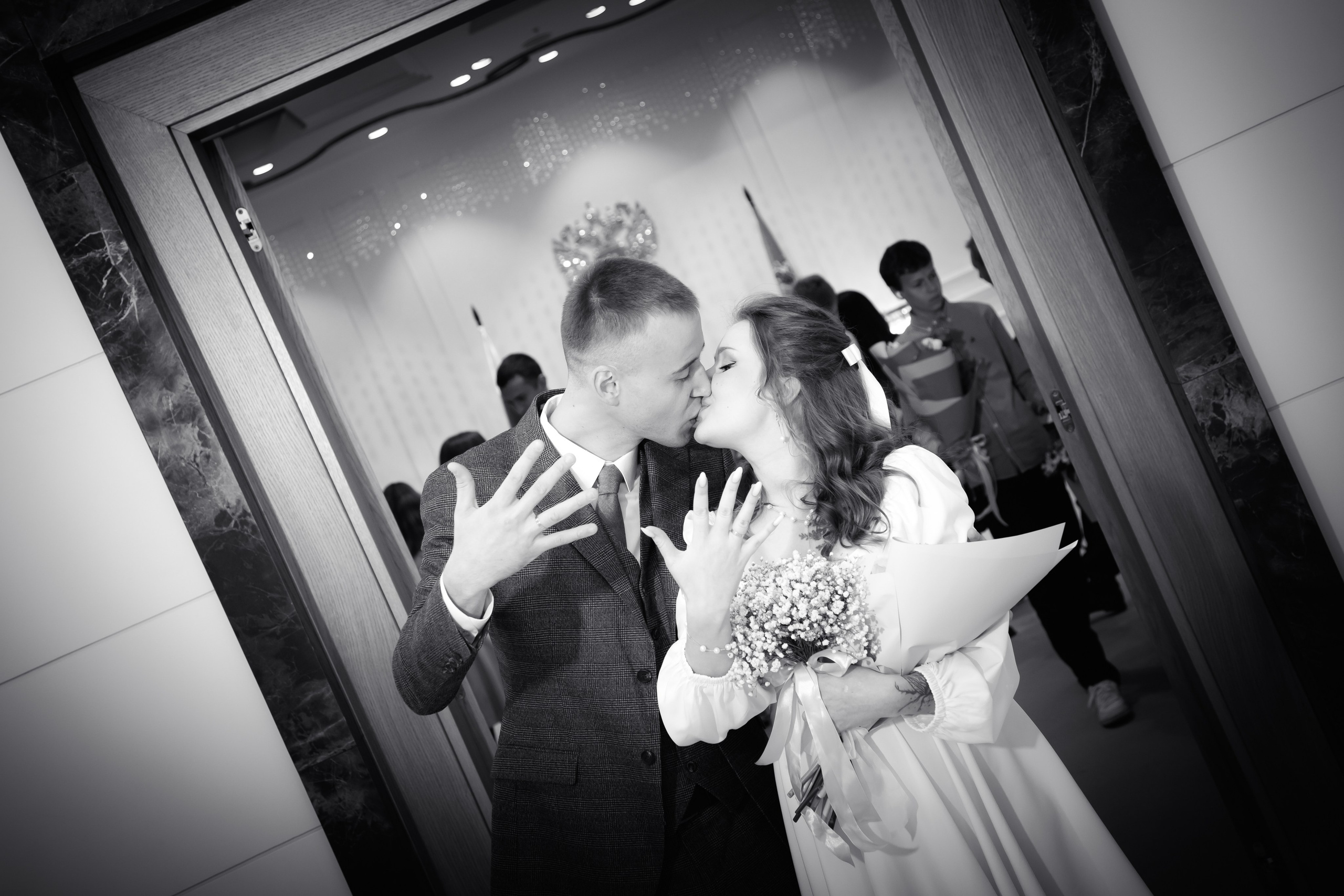 черно белое фото где жених и невеста целуются и показывают руки с кольцами которые только что надели друг другу