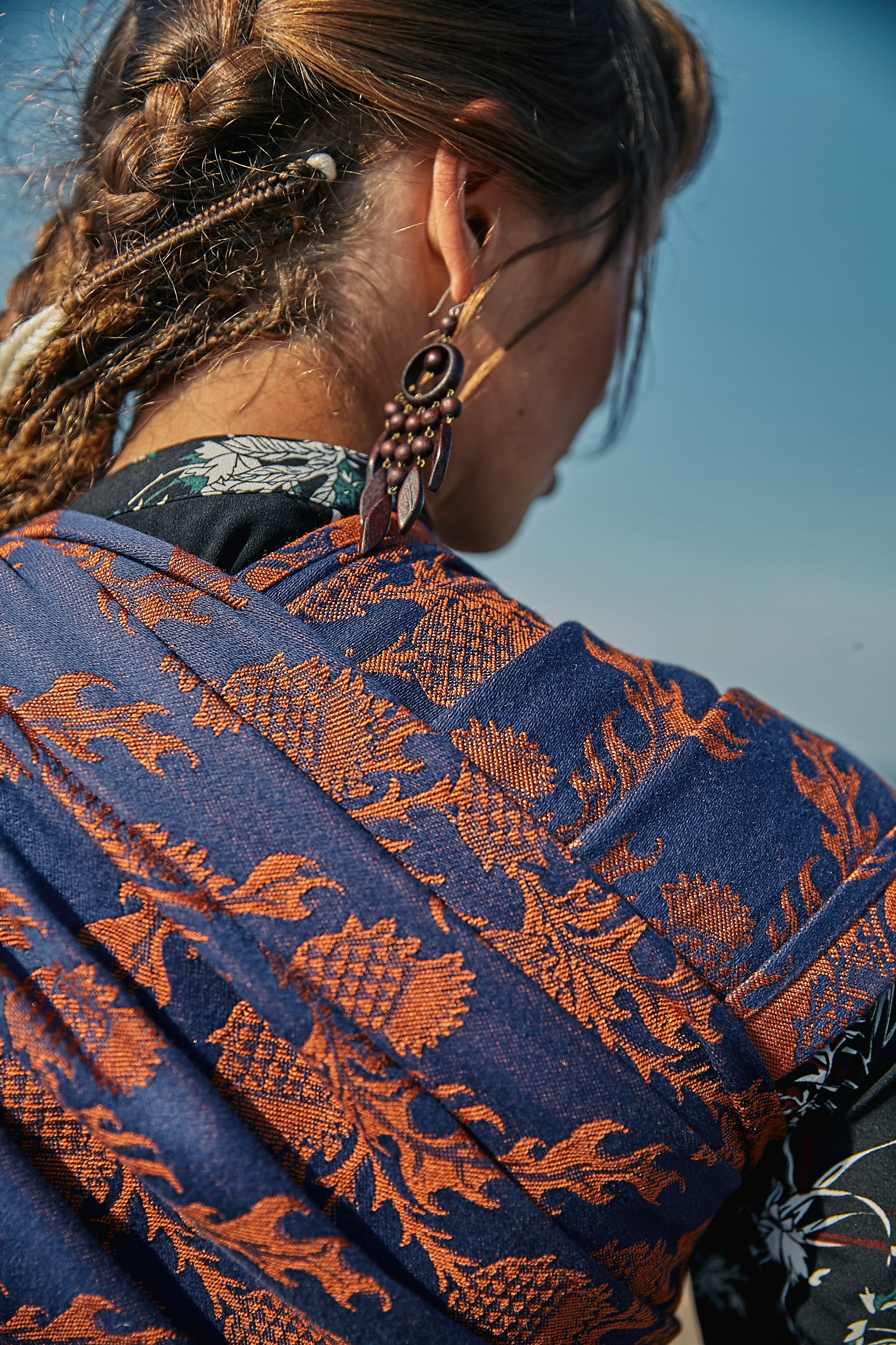 Крупный принт слинга черно оранжевого на плече у девушки