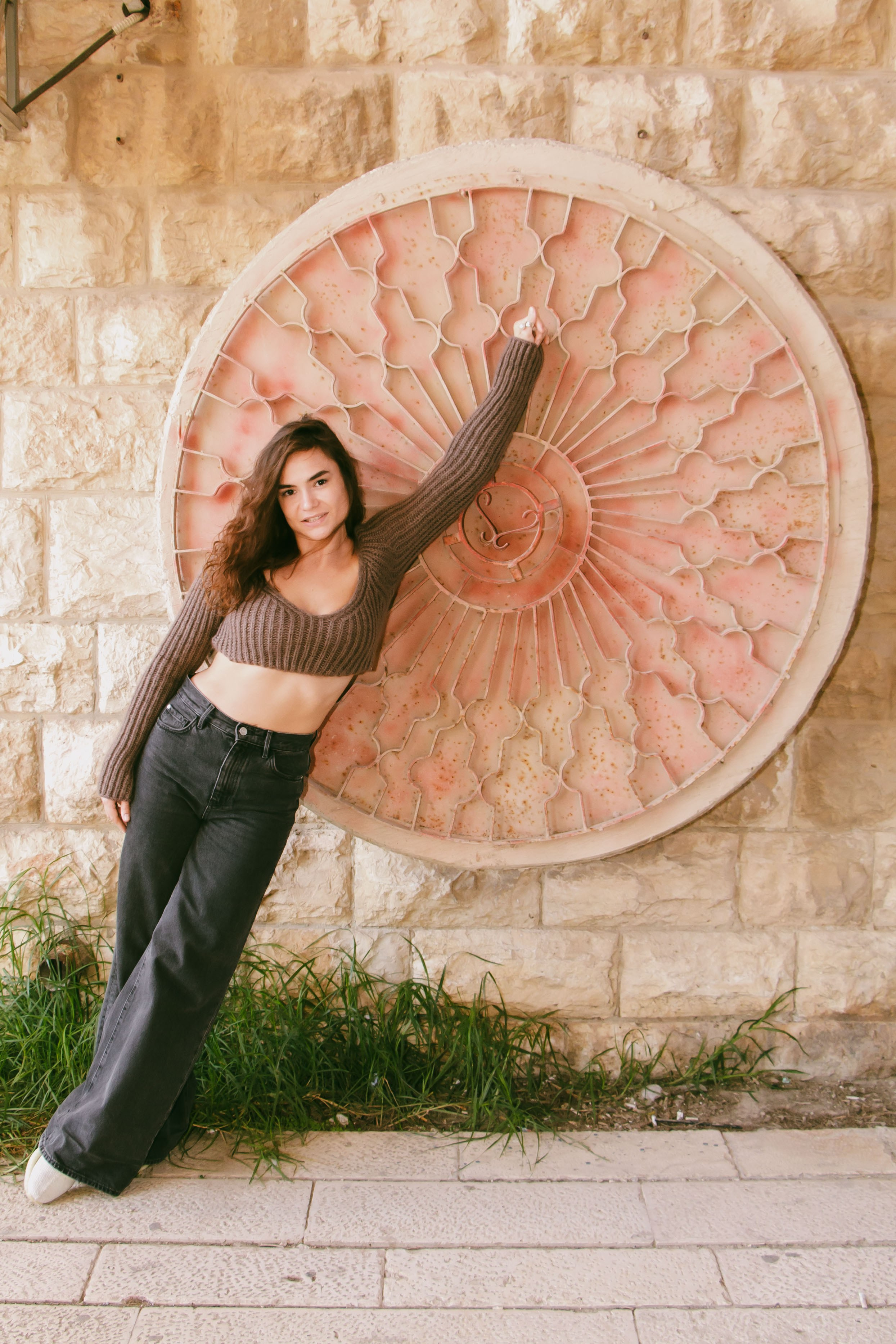 девушка позирует возле круглого объекта