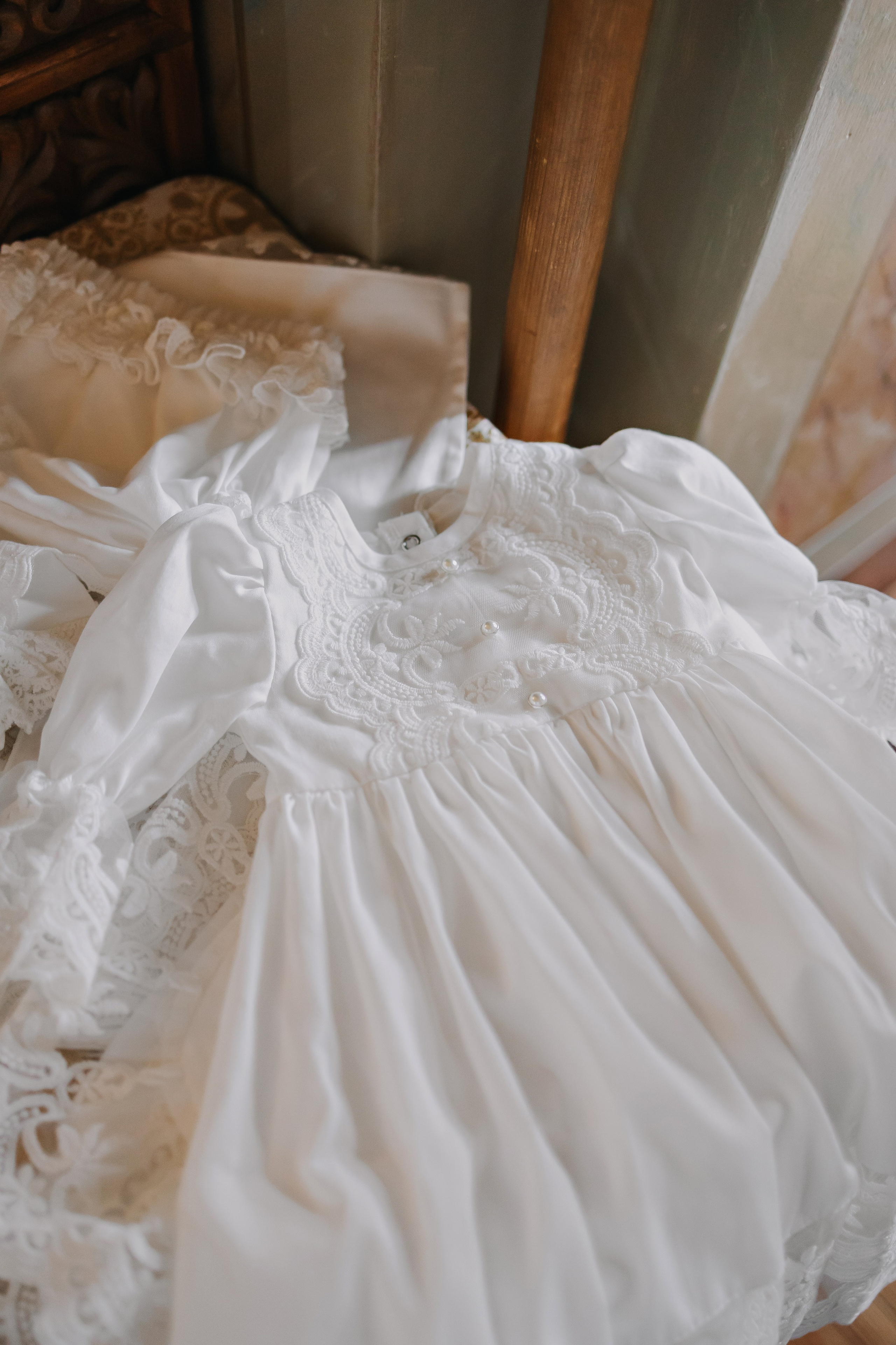 Ребенок в светлом наряде, улыбающаяся мама.