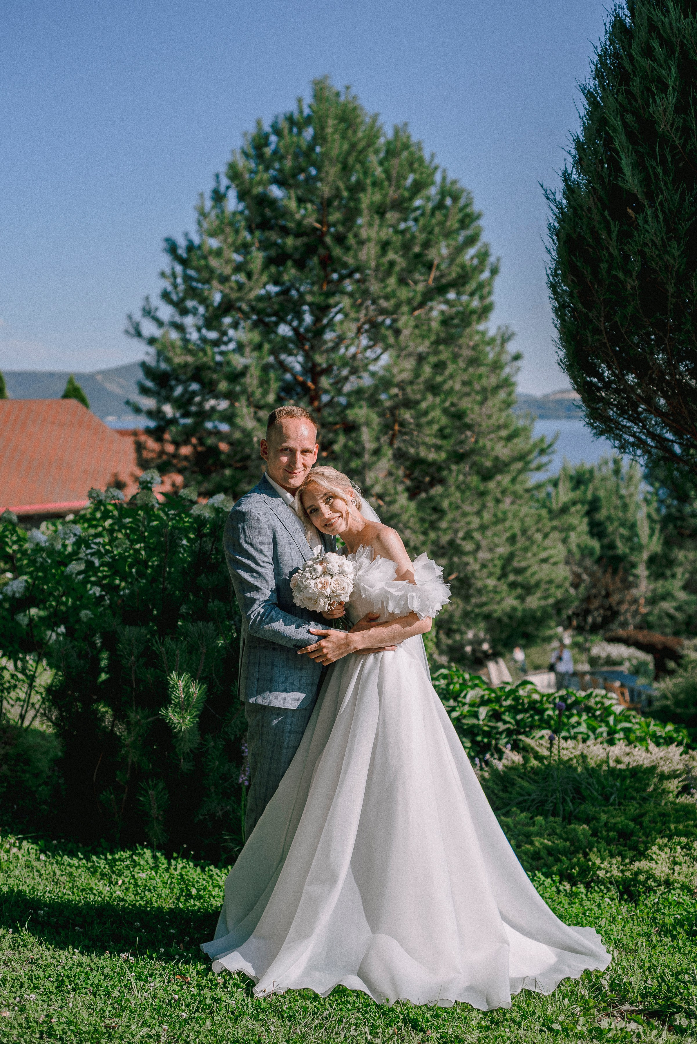 Жених обнимает невесту в полный рос на газоне на территории отеля