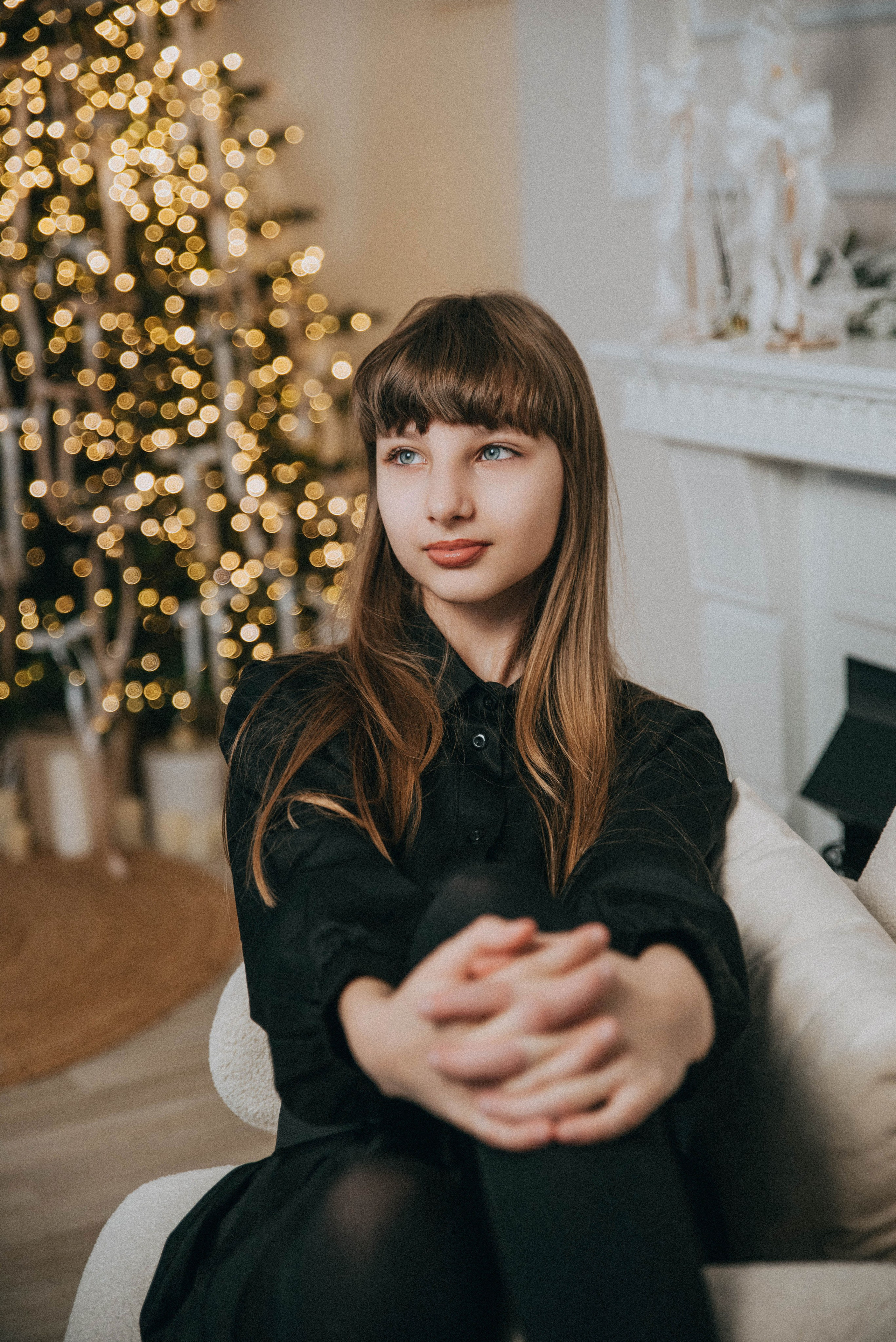 Девочка позирует у ёлки на новогодней фотосессии у фотографа 