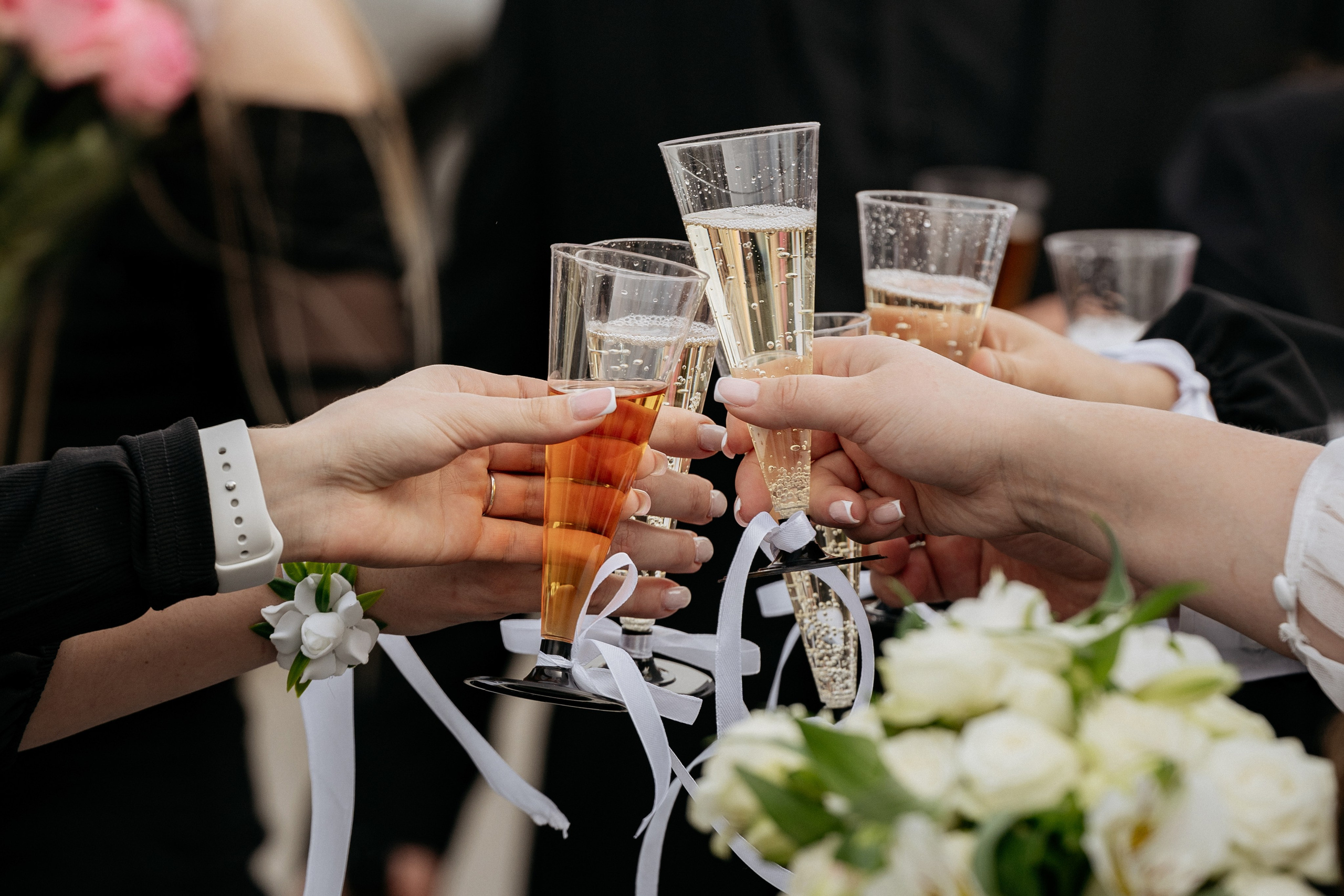 Счастливые друзья поздравляют молодожен около ЗАГСа в Новороссийске, стукаются бокалами