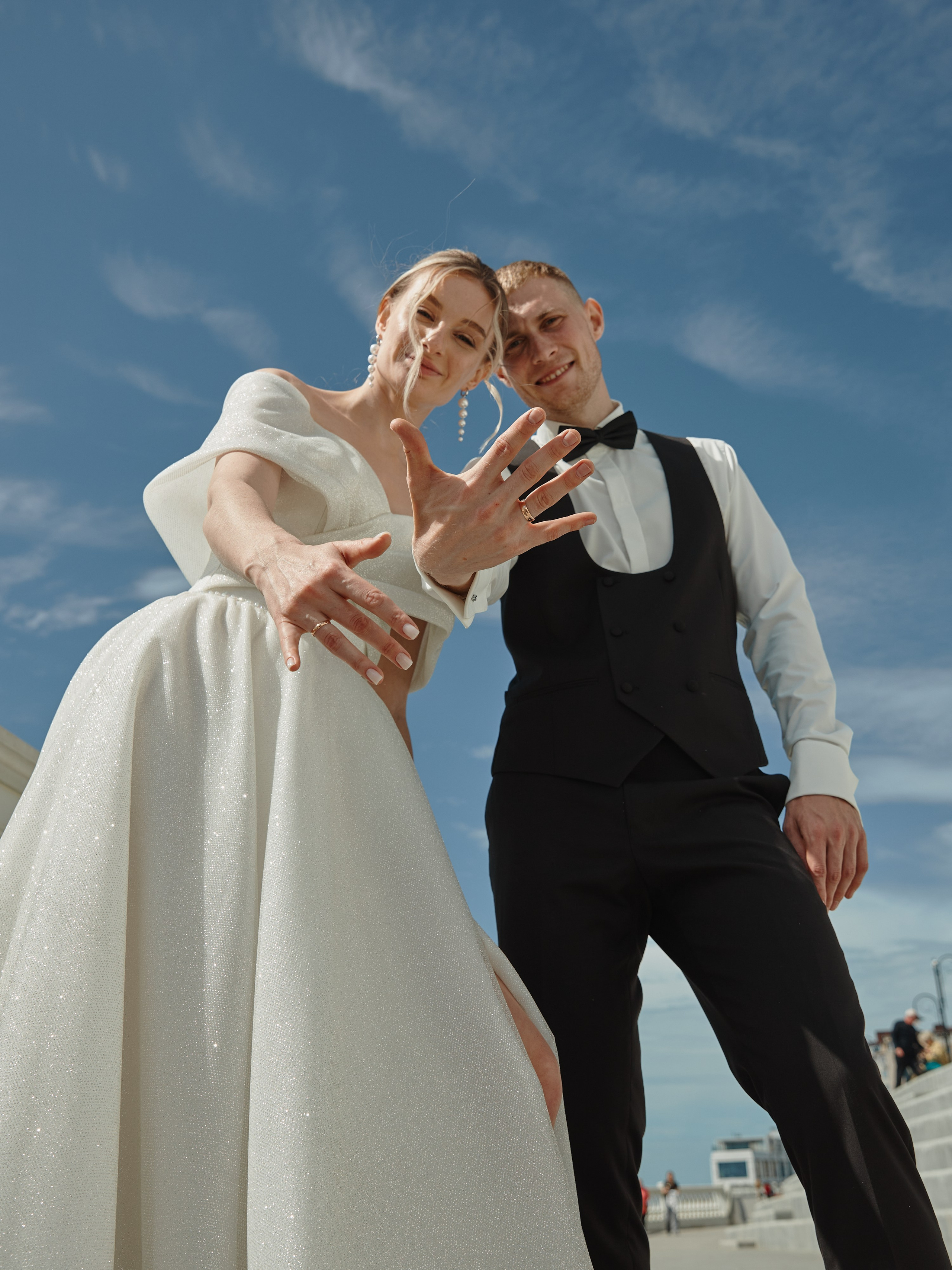 Молодожены показывают кольца в камеру на набережной Анапы