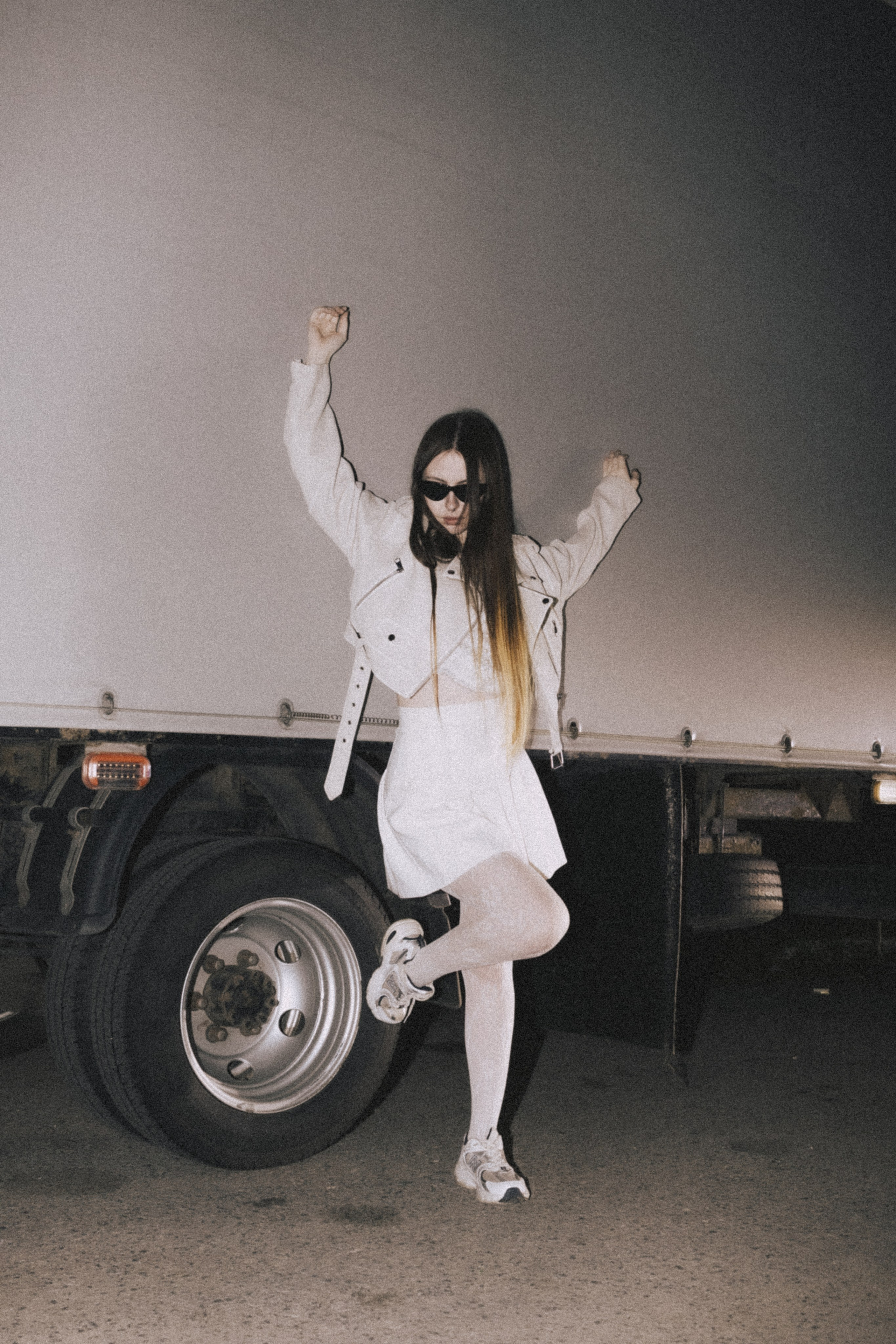 Девушка в белом костюме и очках позирует у большого прицепа грузовика ночью в Пензе. Фото Александра Овечкина