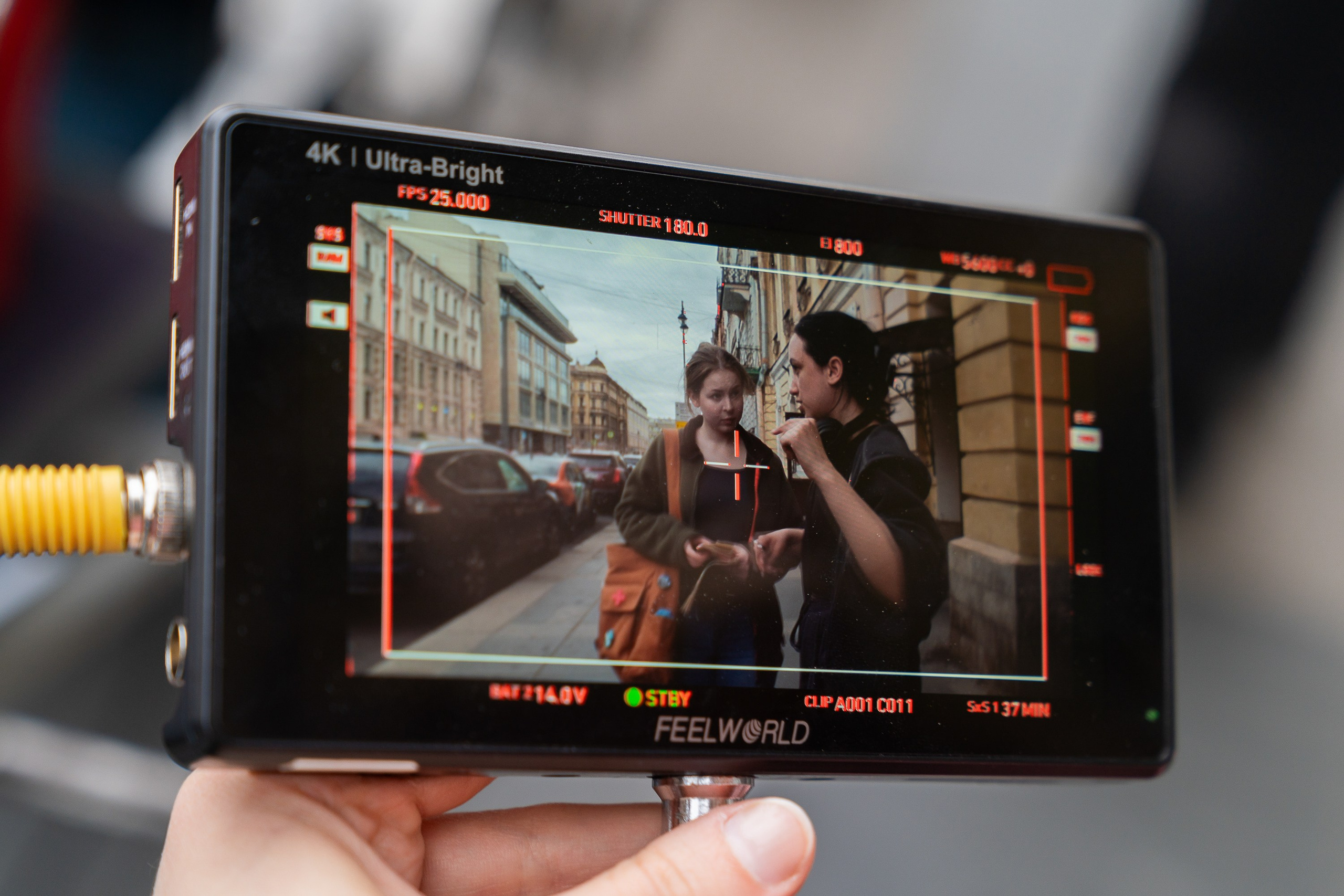 Монитор Feelworld с кадром где режиссер объясняет сцену героине на  локации в Петербурге. Бекстейдж, автор Мальцев Евгений.