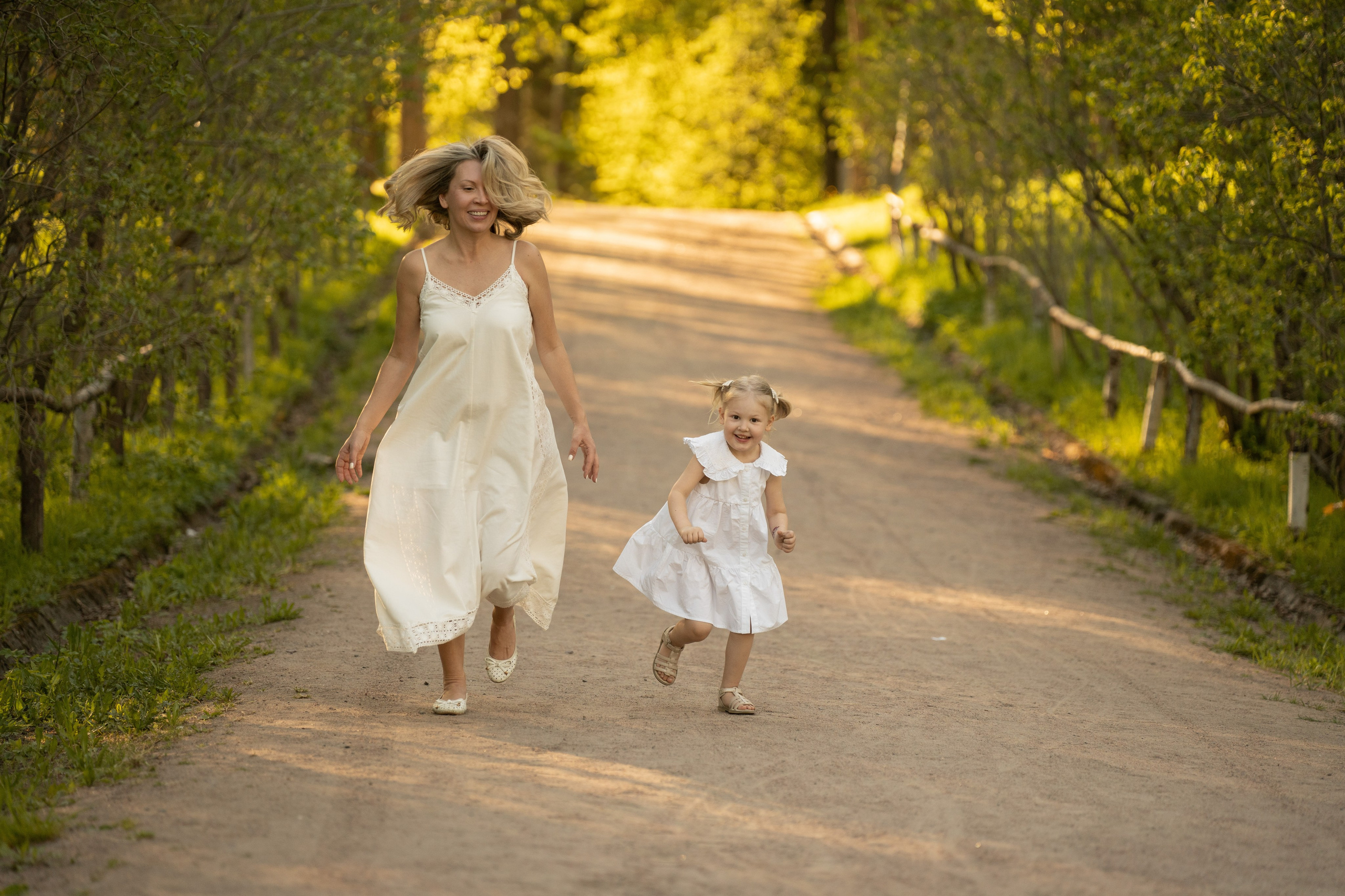 Мама с дочкой бегут с горочки в летнем парке