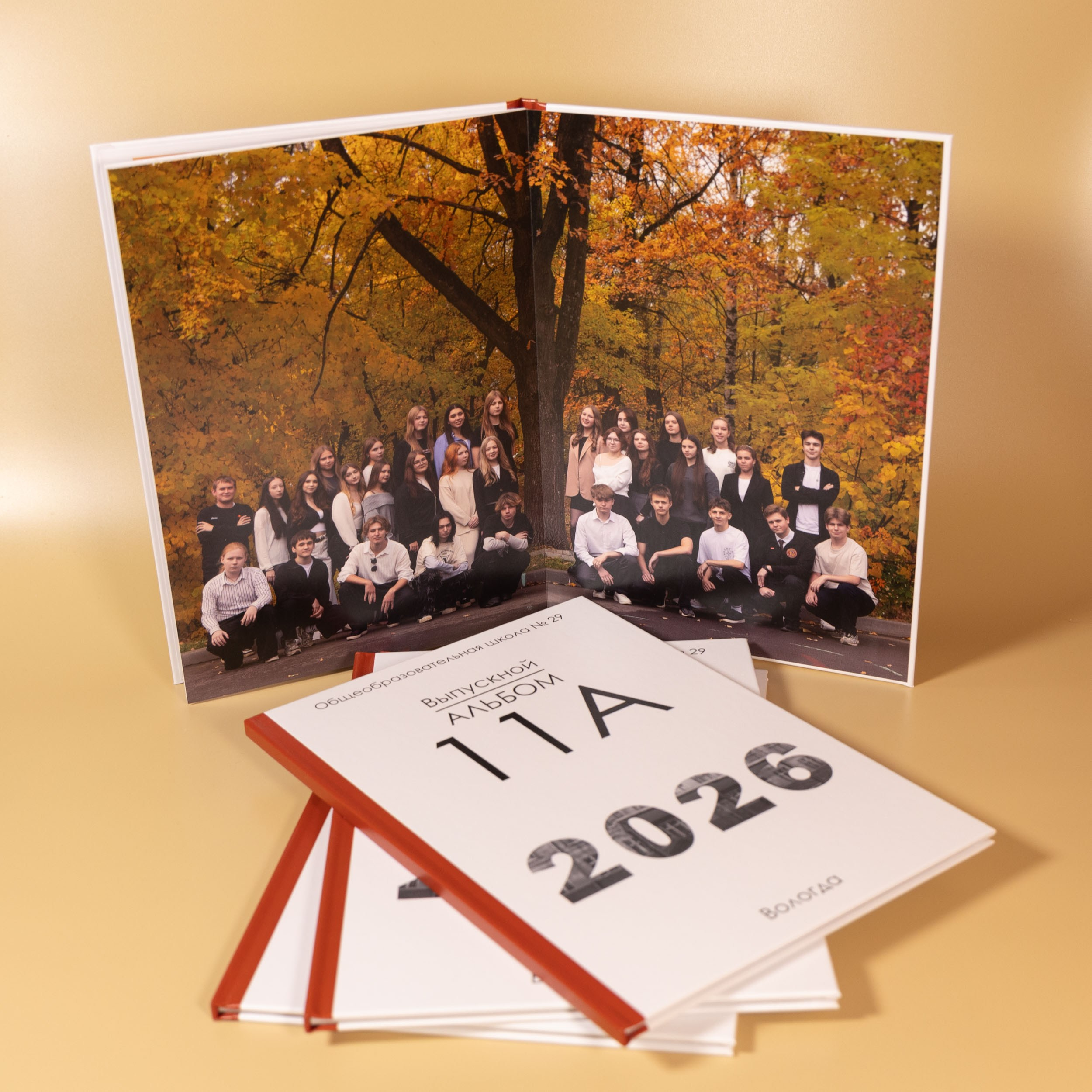 Разворот выпускной фотокниги с общей осенней фотографией.